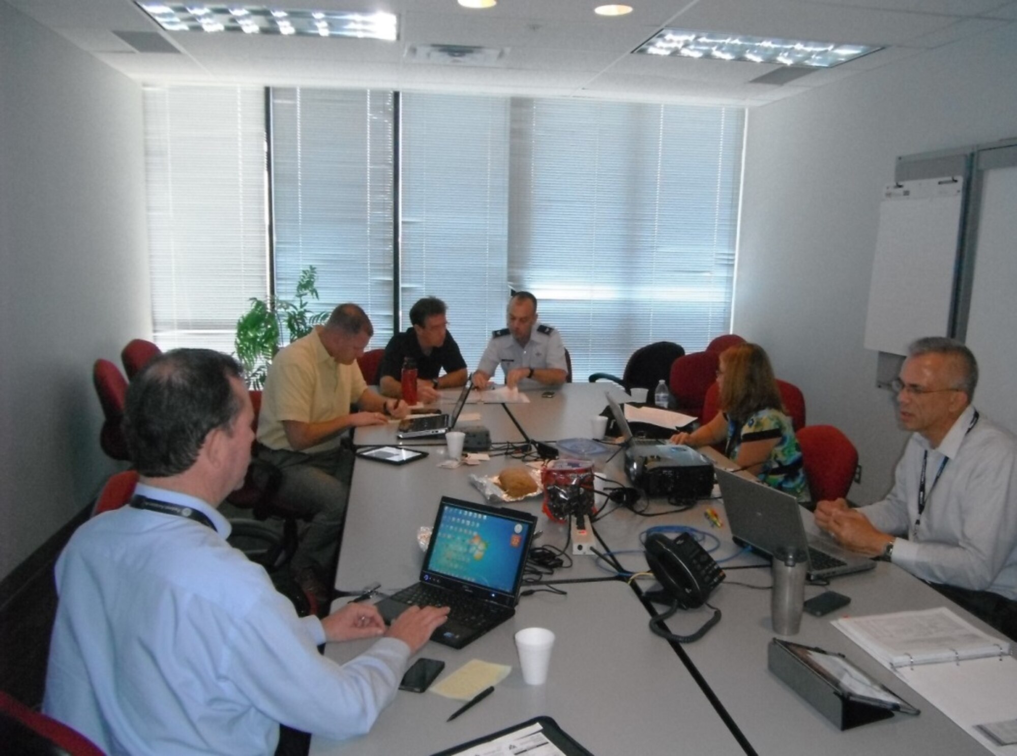 172nd Airlift Wing Commander and American Airlines pilot, Col Tod Wall, (dark blue shirt in middle) and Director of ANG Safety, Col Ed Vaughan, (pictured in uniform), participate in an actual ASAP review panel with representatives of management, the pilots’ union, and FAA regulators. Courtesy Photo