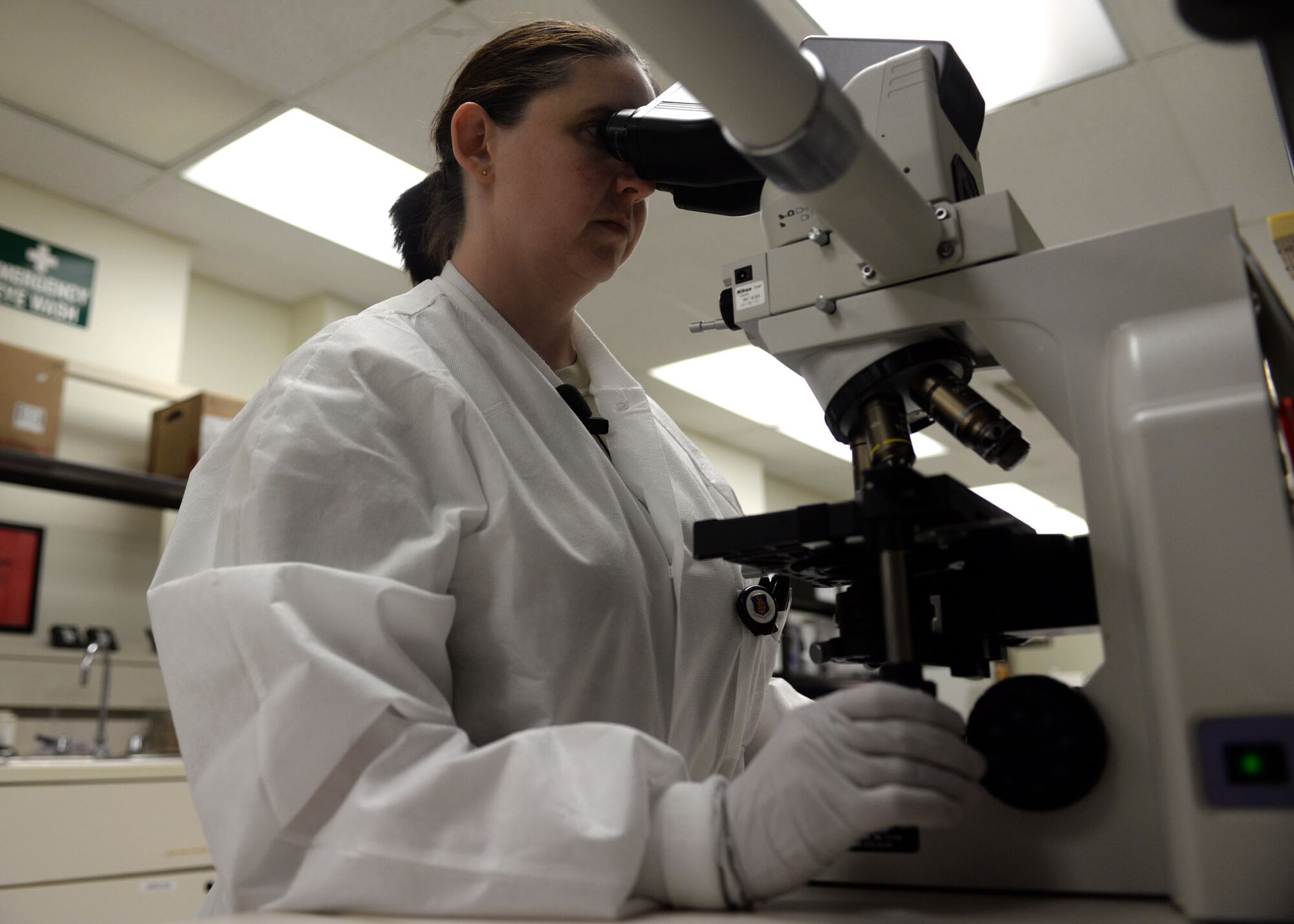 ALTUS AIR FORCE BASE, Okla. – U.S. Air Force Tech. Sgt. Kristi Jordan, 97th Medical Support Squadron NCO in charge of laboratory service, looks at a blood sample through a microscope at the laboratory, Jan. 13, 2015.Dependeing on a patient’s symptoms their provider can order a lab test to determine whether the individual has a certain health concern or not. (U.S. Air Force photo by Senior Airman Franklin R. Ramos/Released)