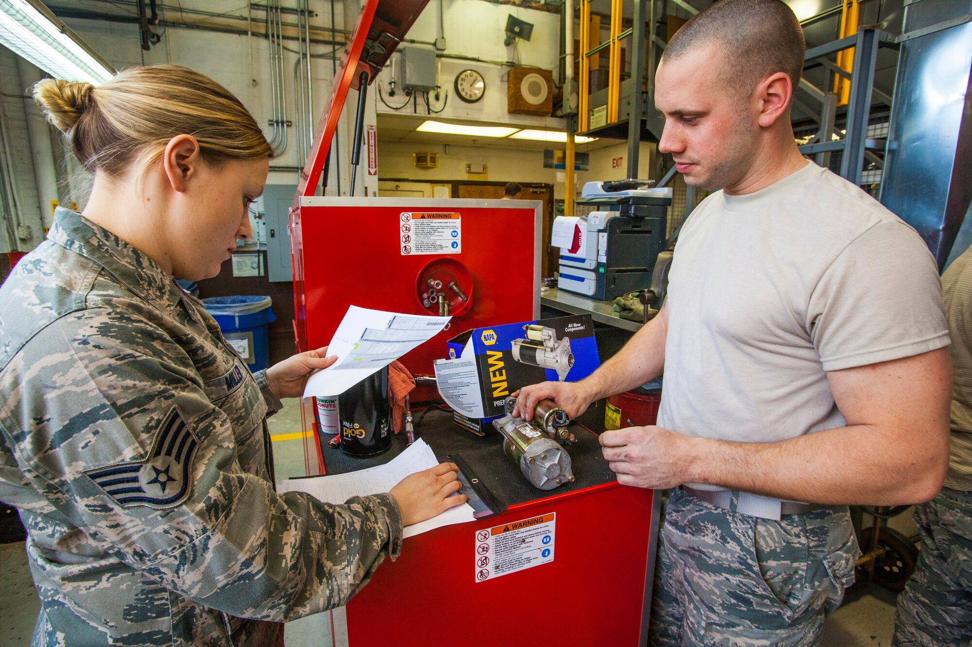 Senior Airman Keith Miller, right, describes to Staff Sgt. Danielle Miller what broke on the starter for a six-passenger pickup truck at the 108th Wing Vehicle Maintenance Shop at Joint Base McGuire-Dix-Lakehurst, N.J., Jan. 11, 2015. Staff Sgt. Miller is a vehicle management and analysis technician with the 108th Vehicle Management Section, while Senior Airman Miller is a general purpose mechanic with the 108th Vehicle Maintenance Shop. Vehicle maintenance is part of the 108th Logistics Readiness Squadron, New Jersey Air National Guard. (U.S. Air National Guard photo by Master Sgt. Mark C. Olsen/Released)
