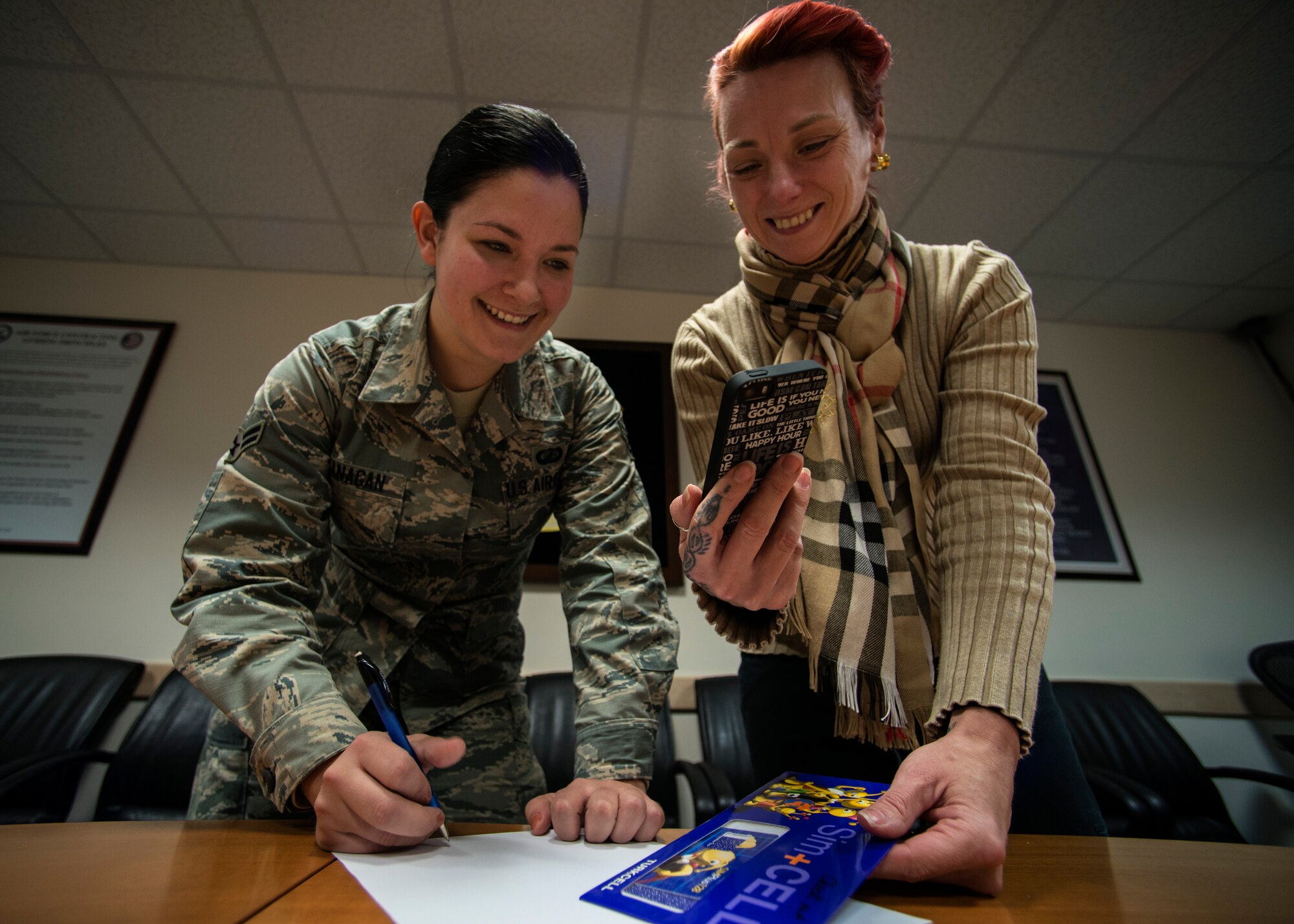 Airman 1st Class Crystal Flanagan, 39th Contracting Squadron contracting administrator, and Lois Ritter, 39th CONS contracting specialist, finalize a contract for a government cell phone Jan. 8, 2015, at Incirlik Air Base, Turkey. The 39th CONS maintains management for a $550 million portfolio of mission-essential and quality of life services, while sustaining $4.1 billion in real property, 467 buildings, 900 government housing units and three geographically-separated units.(U.S. Air Force photo by Airman Cory W. Bush/Released)