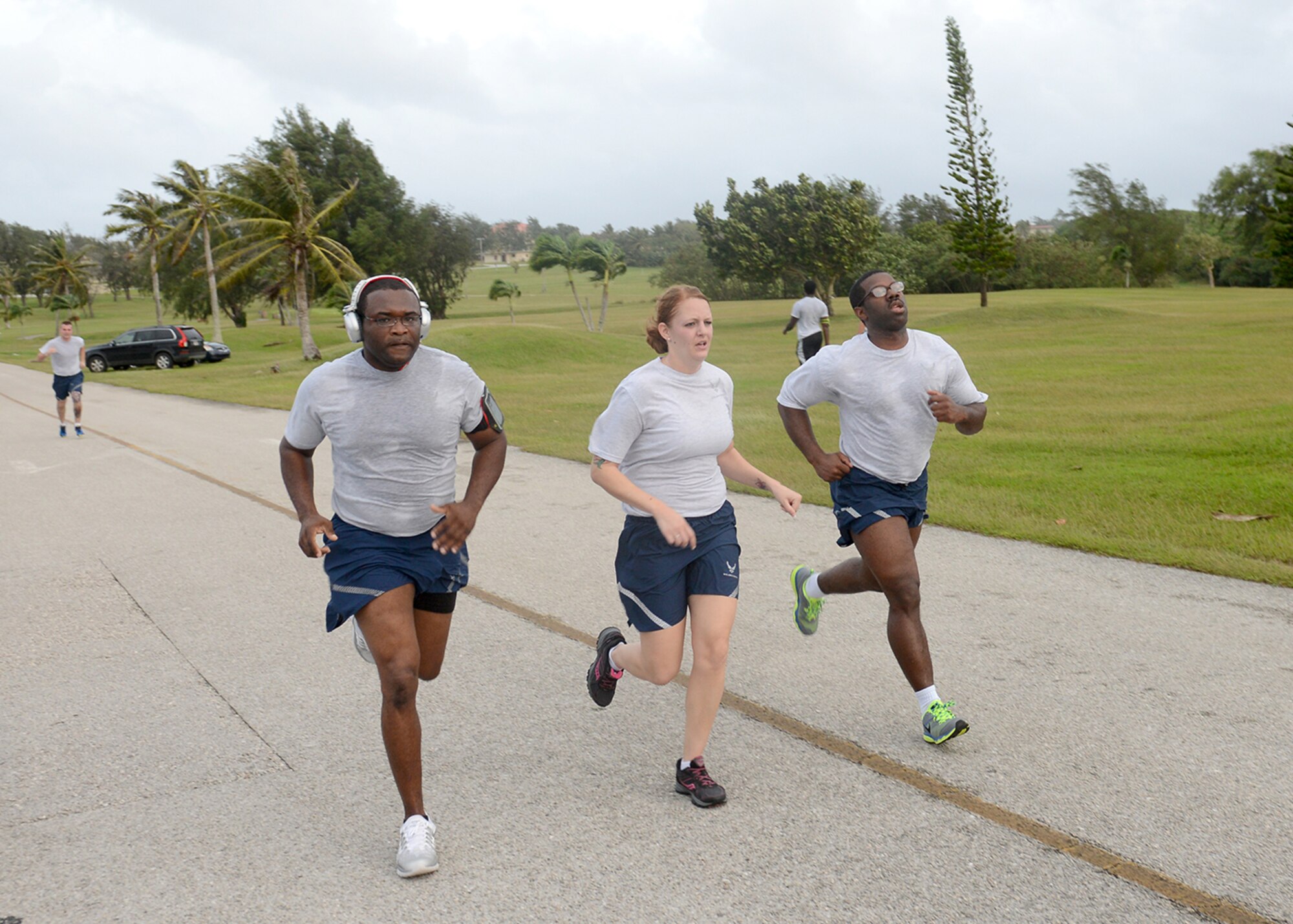 Three Team Andersen Airmen dig deep to finish the New Year’s Hustle 5K Jan. 14, 2015 at Andersen Air Force Base, Guam.  Participants from across the base joined together to power through gusty winds and finish Andersen’s first 5K run of 2015. (U.S. Air Force photo by Tech. Sgt. Zachary Wilson/Released.)