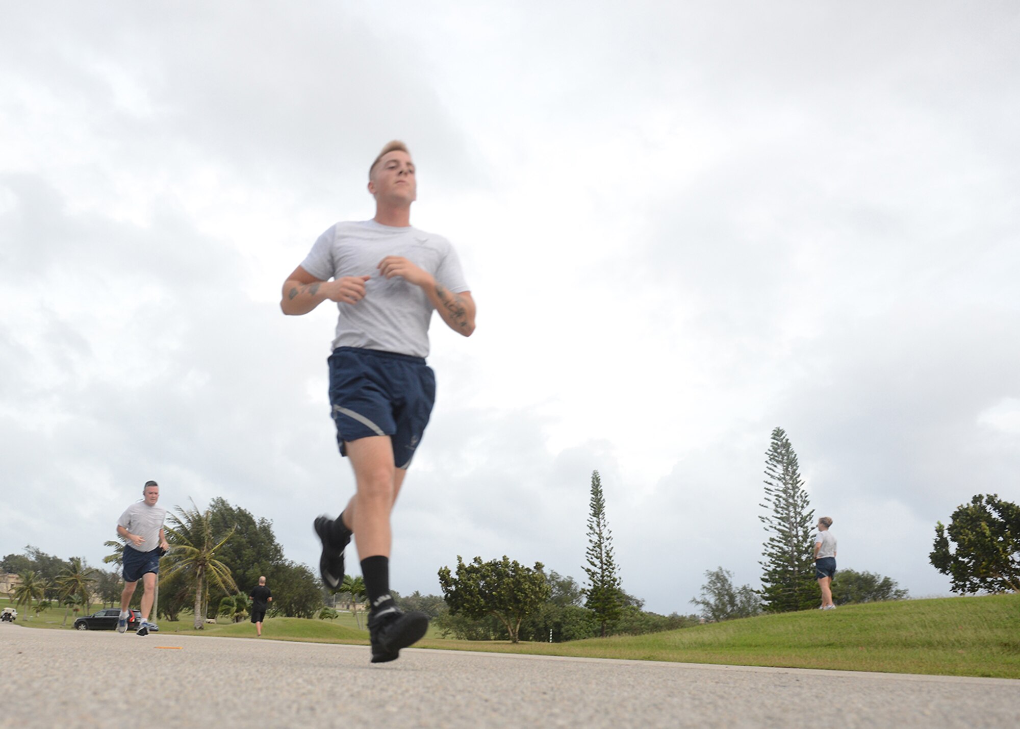 Senior Airman Nathan Oliver, 36th Munitions Squadron, sprints to finish the last 100 feet of the New Year’s Hustle 5K run Jan. 14, 2015 at Andersen Air Force Base, Guam. Participants from across the base joined together to power through gusty winds and finish Andersen’s first 5K run of 2015. (U.S. Air Force photo by Tech. Sgt. Zachary Wilson/Released.)