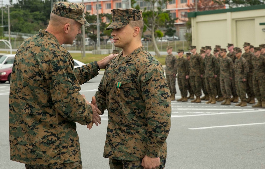 Col. Lance A. McDaniel, left, congratulates Sgt. Jacob J. Baumann Jan. 14 on receiving the Navy and Marine Corps Achievement Medal for potentially saving the life of a local Japanese gentleman. “Heroism often involves an ordinary man doing extraordinary things for others,” said McDaniel from Waco, Texas. “Recently Sgt. Baumann saw the opportunity and didn’t spend time thinking; he acted on behalf of someone else.” McDaniel is the commanding officer of 12th Marine Regiment, 3rd Marine Division, III Marine Expeditionary Force. Baumann is from Junction City, Kansas, and a fire support man with Headquarter Battery, 12th Marine Regiment. 