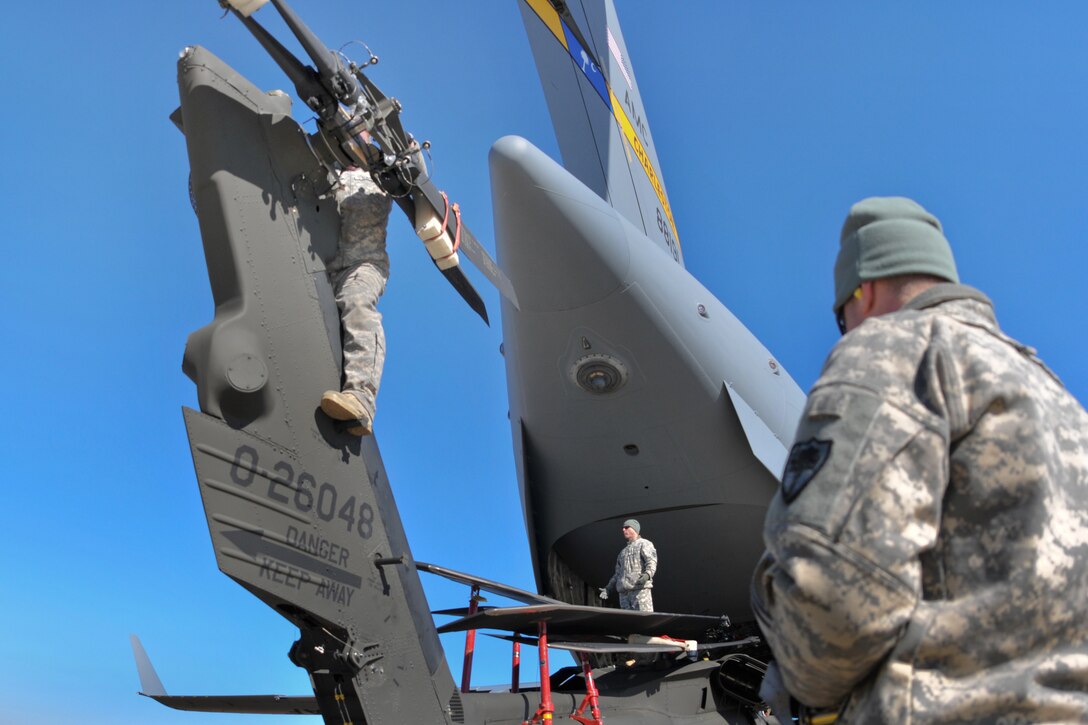 A soldier safely secures the tail rotors before loading a UH-60 Black Hawk helicopter onto a C-17 Globemaster III aircraft during drill weekend on McEntire Joint National Guard Base in Eastover, S.C., Jan. 10, 2015.