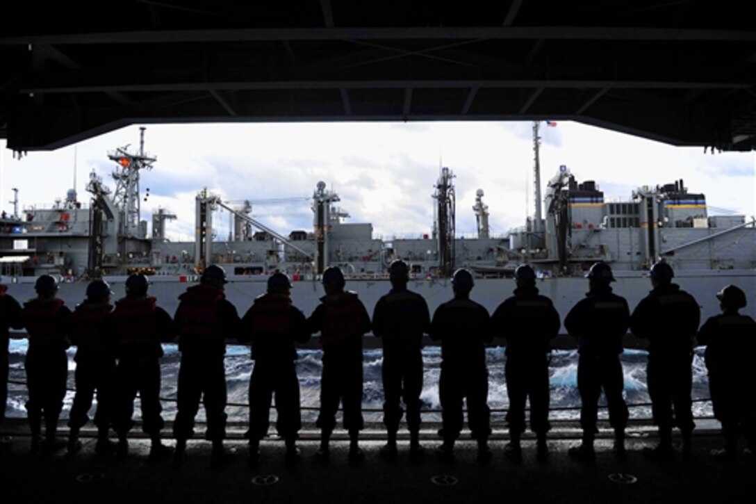 U.S. sailors on the aircraft carrier USS Theodore Roosevelt participate in a replenishment at sea with the fast combat support ship USNS Arctic in the Atlantic Ocean, Jan. 11, 2015. 