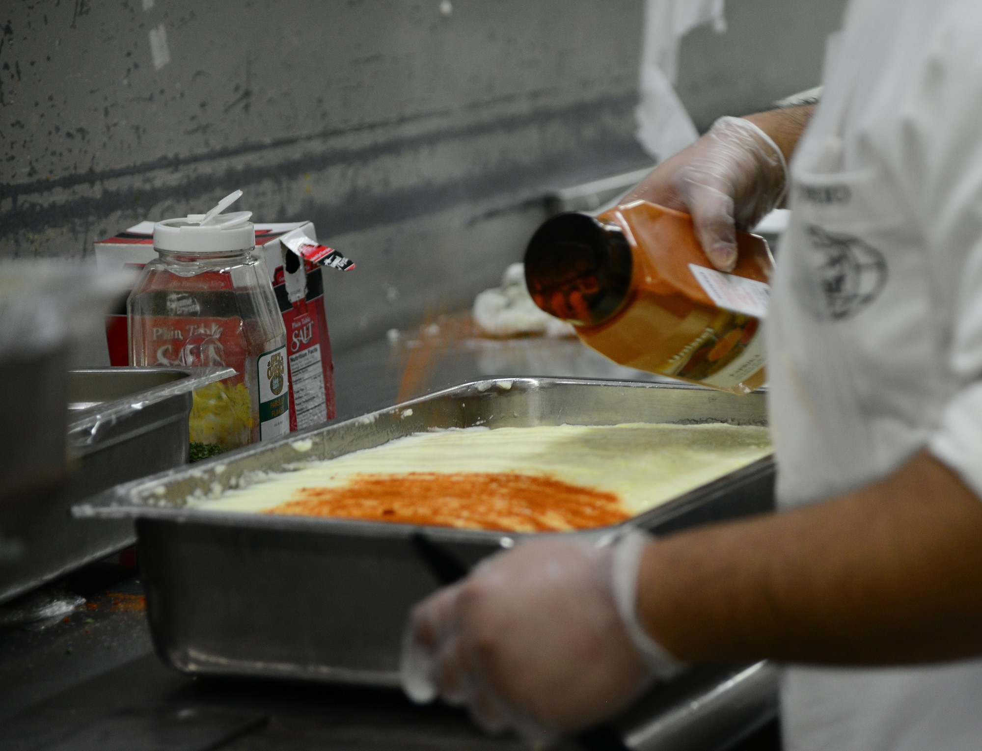 A food service contractor prepares meals for U.S. servicemembers at one of three dining facilities at Al Udeid Air Base, Qatar.  The 379th Expeditionary Force Support Squadron at AUAB serves meals to over 15,000 servicemembers daily.  (U.S. Air Force photo by Senior Airman Kia Atkins)