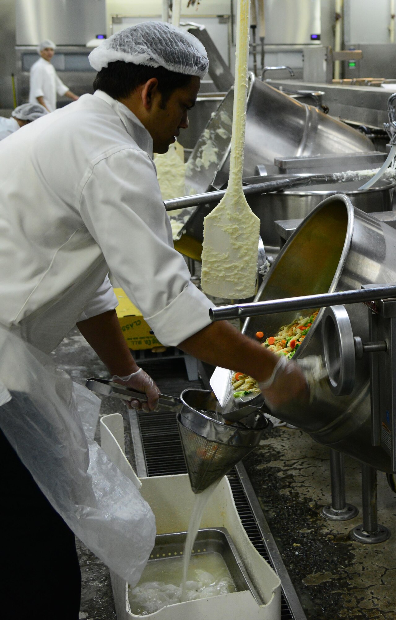 A food service contractor prepares meals for U.S. servicemembers at one of three dining facilities at Al Udeid Air Base, Qatar.  The 379th Expeditionary Force Support Squadron at AUAB serves meals to over 15,000 servicemembers daily.  (U.S. Air Force photo by Senior Airman Kia Atkins)