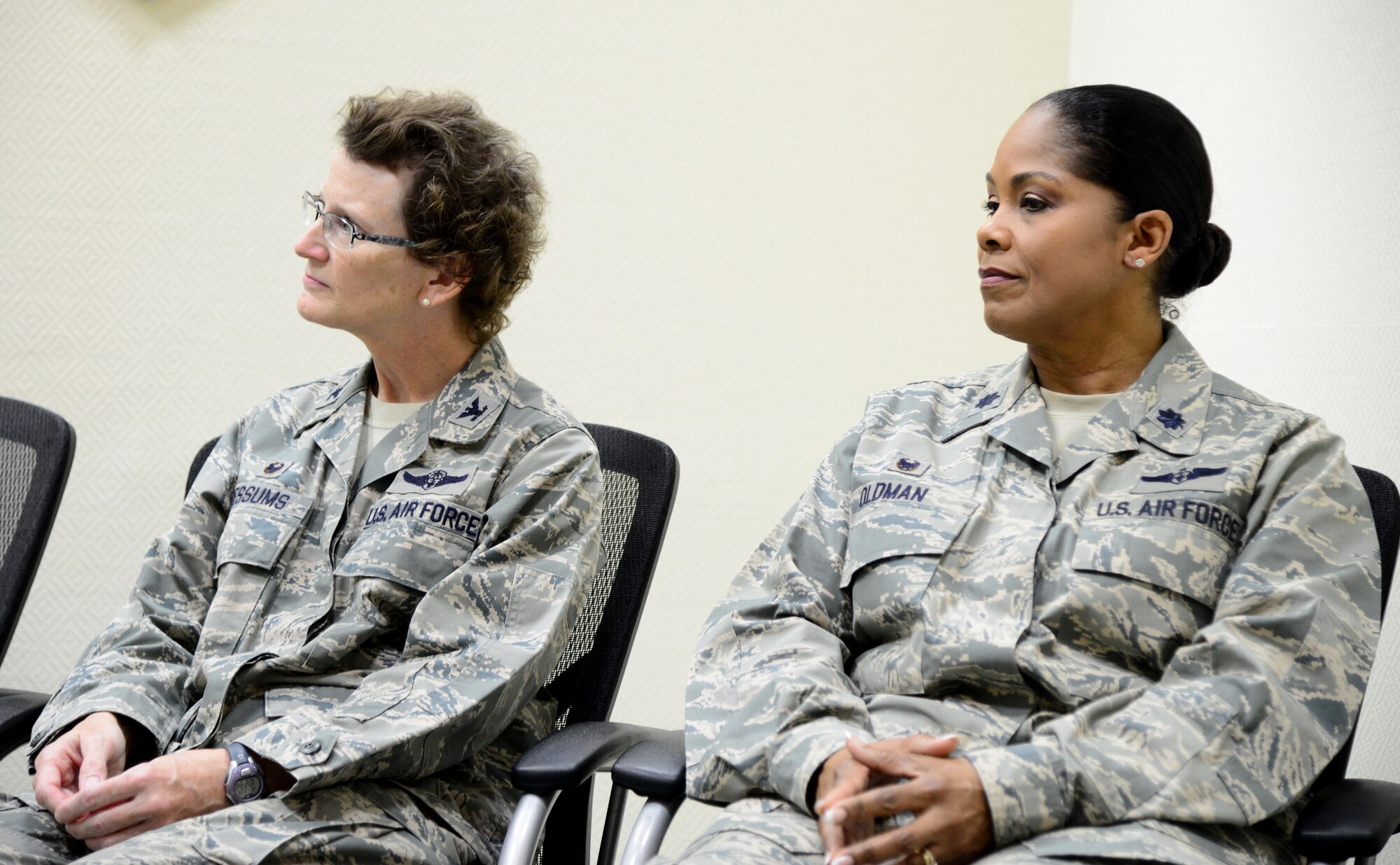 U.S. Air Force Col. Janet Sessums, left, and Lt. Col. June Oldman listen to opening remarks during the 379th Expeditionary Aeromedical Evacuation Squadron change of command ceremony, Jan. 14, 2015, at Al Udeid Air Base, Qatar. Oldman assumed command of the 379 EAES from Sessums, who will redeploy to her home unit, the 137th Aeromedical Evacuation Squadron at Will Rogers Air National Guard Base, Okla., where she is the director of operations. (U.S. Air Force photo by Senior Airman Kia Atkins)
