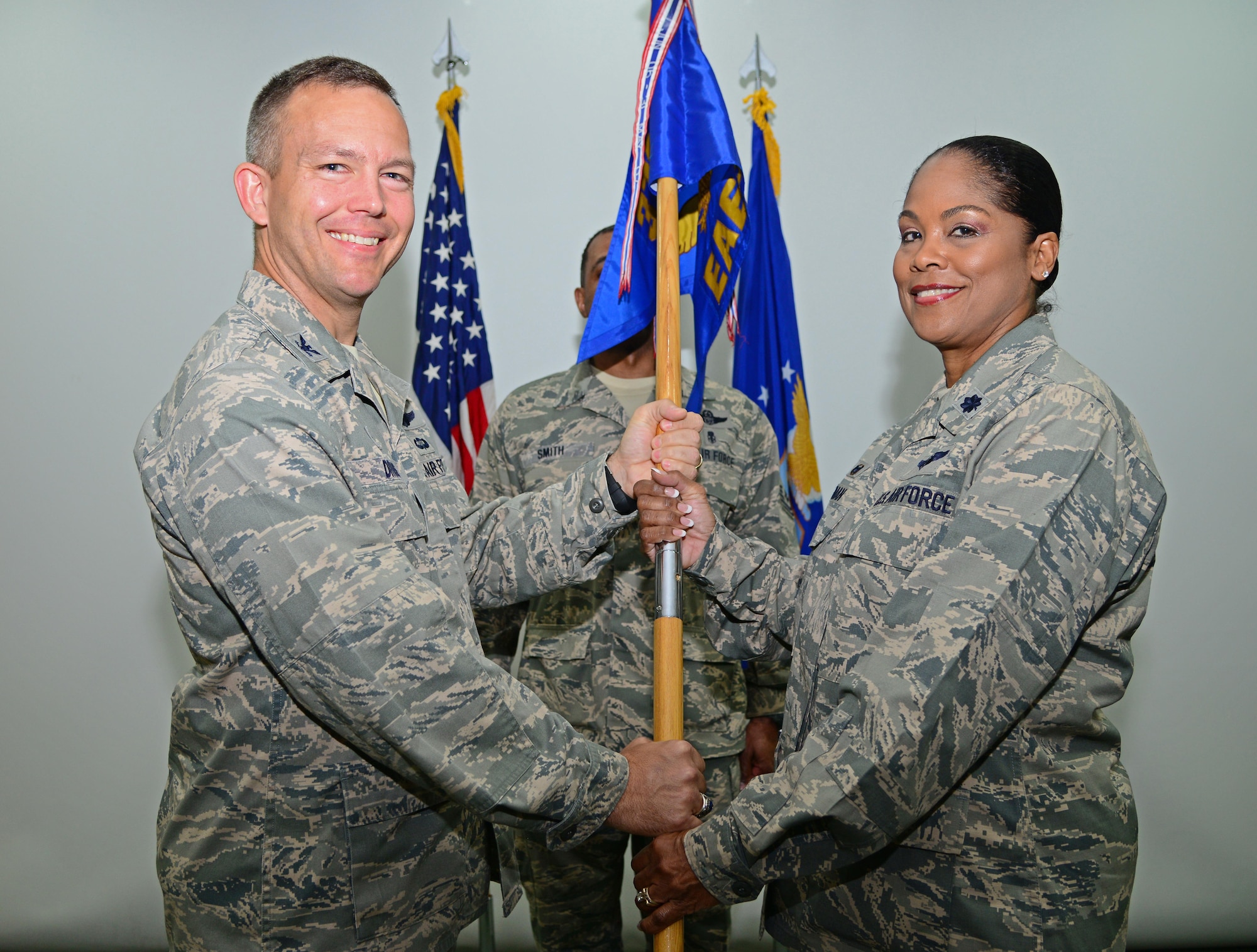 U.S. Air force Jim Dittus, 379th Expeditionary Operations Group commander, hands Lt. Col. June Oldman the 379th Expeditionary Aeromedical Evacuation Squadron guidon during a change of command ceremony, Jan. 14, 2015, at Al Udeid Air Base, Qatar. Oldman assumed command of the 379th EAES from Col. Janet Sessums, who will redeploy to her home unit, the 137th Aeromedical Evacuation Squadron at Will Rogers Air National Guard Base, Okla., where she is the director of operations. (U.S. Air Force photo by Senior Airman Kia Atkins)