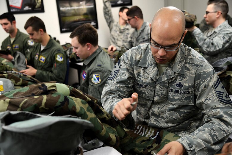 Senior Master Sgt. Carl James, 47th Medical Group and Wing Staff Agencies First Sergeant, prepares his chemical protective overgarments during a chemical, biological, radiological, and nuclear survival skills class at the readiness and emergency management flight on Laughlin Air Force Base, Texas, Jan. 14, 2015. Class attendees were expected to prepare and inspect their own equipment to ensure their preparedness for a real-world event. (U.S. Air Force photo by Airman 1st Class Ariel D. Delgado)