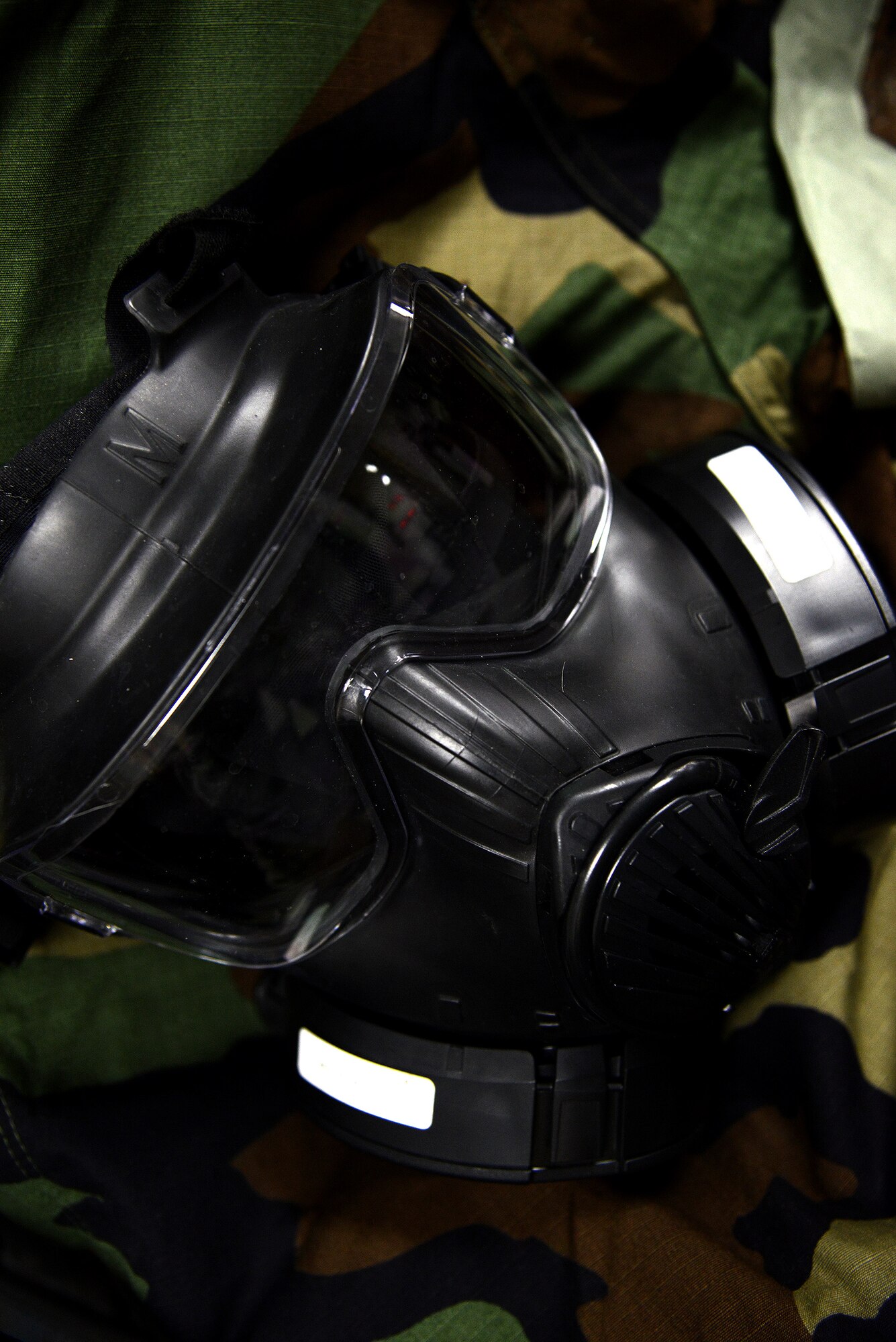 An M50 chemical protective mask rests on a ground crew ensemble at the readiness and emergency management flight on Laughlin Air Force Base, Texas, Jan. 12, 2014. The M50 allows for a wide field of view with a single lens that spans the width of the face and provides 24 hours continuous eye-respiratory protection in chemical, biological, radiological, and nuclear environments. (U.S. Air Force photo by Airman 1st Class Ariel D. Delgado)