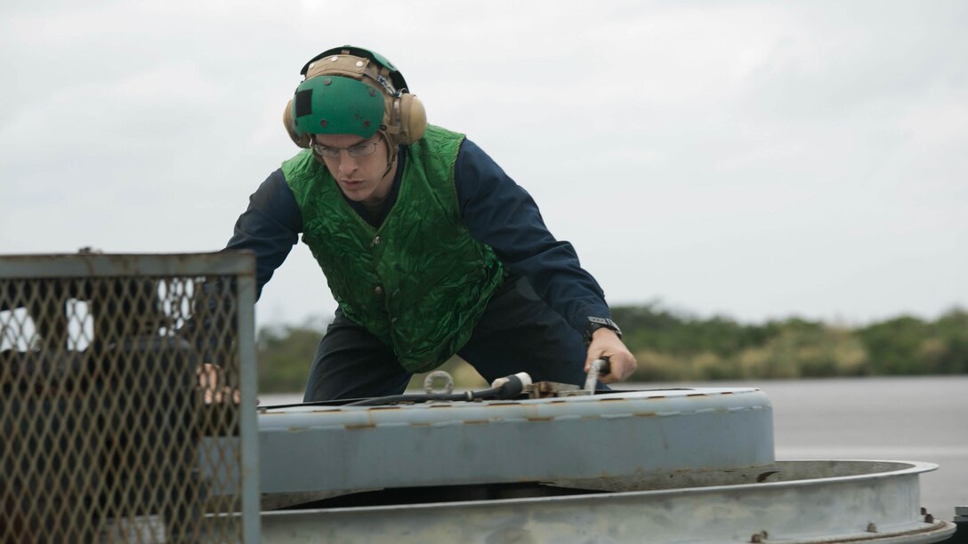 Lance Cpl. Ronald Summerlin cranks a tape reel to pull back the arresting wire Jan. 9 during arrested landing safety training at Marine Corps Air Station Futenma. Arrested landings are the use of equipment, such as a safety barrier or an arresting wire, to rapidly slow down an aircraft and ensure the landing path is straight and clear. During the training, Marines demonstrated proficiency in the use of arresting equipment while ensuring the safety of personnel and equipment on the airstrip. Summerlin is a Virginia Beach, Virginia, native and an expeditionary airfield systems technician with Headquarters and Headquarters Squadron, MCAS Futenma, Marine Corps Installations Pacific-Marine Corps Base Camp Butler, Japan. 