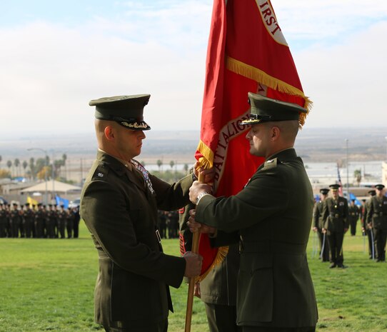 Lt. Col. Seth E. Yost,  a native of Wellsboro, Pa., relinquishes the battalion colors to Lt. Col. David J. Hart, a native of Unity, N.H., during the 1st Battalion, 7th Marine Regiment’s change of command ceremony at Lance Cpl. Torrey L. Gray Field, Dec. 4, 2014. ‘First Team’ has a reputation of great Marines and mission readiness. (Official Marine Corps photo by Lance Cpl. Medina Ayala-Lo/Released)