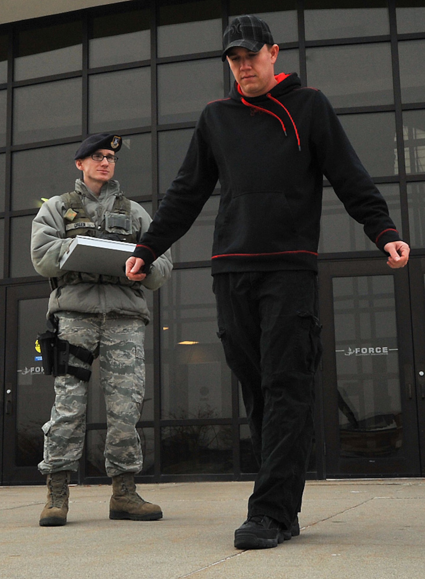 Senior Airman Caleb Green and Airman Bryce Willsey simulate the walk-and-turn portion of the field sobriety test Dec. 10, 2014, on Grand Forks Air Force Base, N.D. The FST consists of three different portions and is used to test a subject who is believed to be intoxicated. During the walk-and-turn portion, the subject is asked to walk nine steps in a straight line, heel-to-toe, and then turn around and walk in the opposite direction in the same fashion with the same number of steps. Green is a 319th Security Forces Squadron base defense operations control controller/patrolman. Willsey is a 319th SFS alarm monitor. (U.S. Air Force photo/Airman 1st Class Bonnie Grantham)