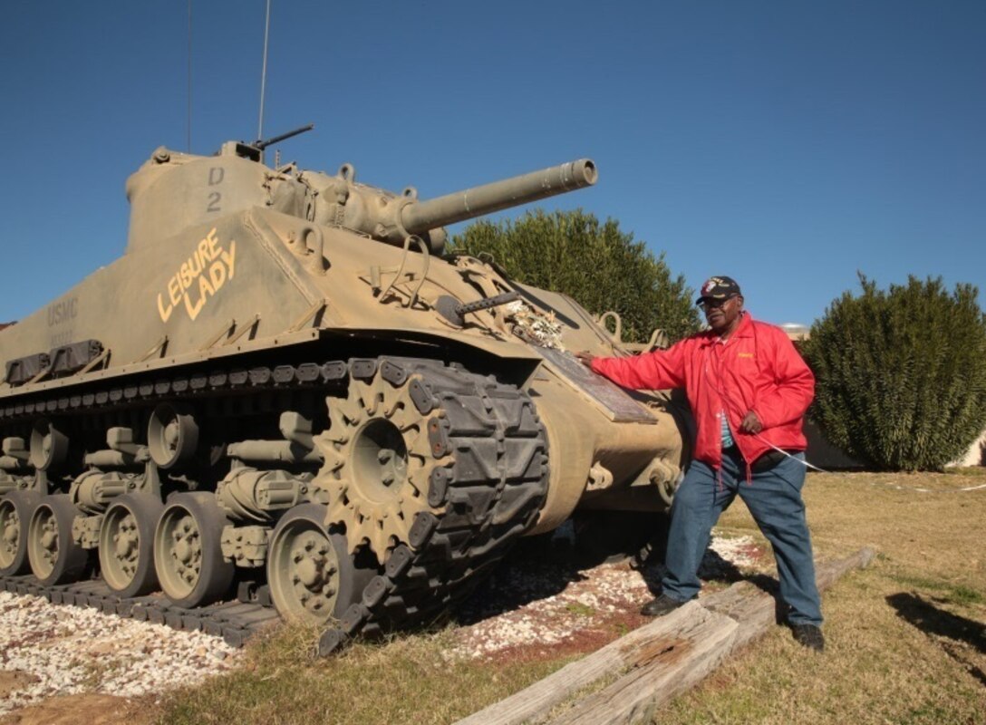 Kenny R. White, Marine veteran, native of San Diego, Calif., poses with a Sherman Tank outside of 1st Tank Battalion’s headquarters building, Dec. 22, 2014. White received a tour of the M1A1 Abrams tank, and was able to see the Advance Gunnery Training Simulator as well. (Official Marine Corps photo by Lance Cpl. Medina Ayala-Lo/Released)