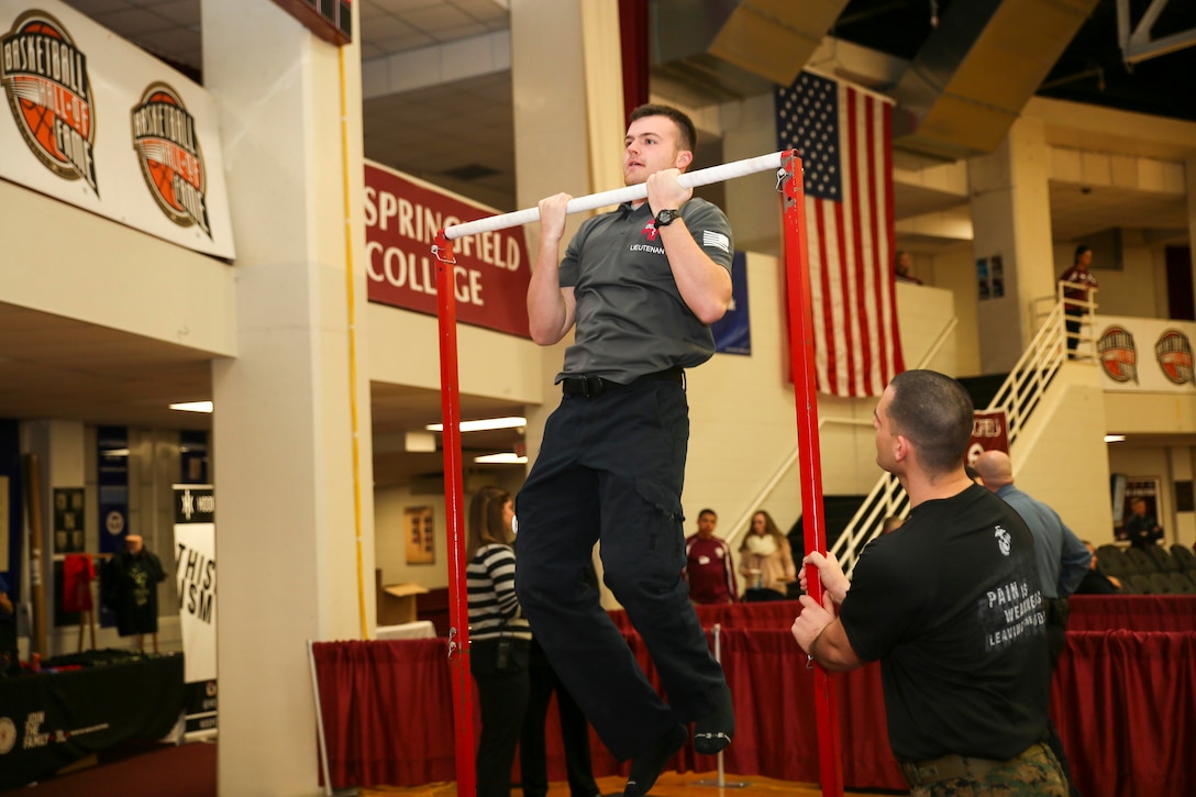 A local emergency medical technician attempt the Marine Corps Pull Up Challenge during the 2015 Spaudling Hoophall Classic. The Marines of Recruiting Station Springfield were in attendance to show support of the local community and young athletes in Springfield Massachusetts, Jan. 15. The Marine Corps takes every opportunity to celebrate student’s excellence in physical fitness, discipline, and commitment.