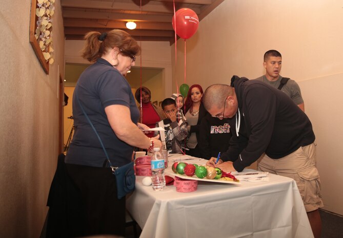 Staff members sign in to the Bob Hope United Service Organization, Palm Springs sponsored Robert E. Bush Naval Hospital holiday party at Smith Ranch, Dec. 11, 2014. The party began with dinner and ended with a holiday raffle. (Official Marine Corps photo by Lance Cpl. Medina Ayala-Lo/Released)