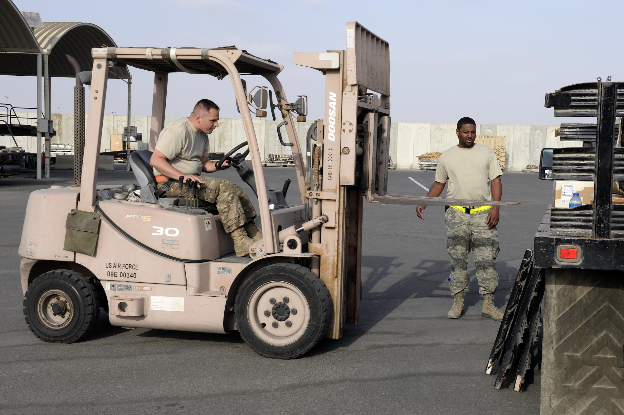 Staff Sgt. James, Traffic Management Office outbound cargo supervisor, guides Tech. Sgt. Jesse, air terminal operations center, as he prepares to unload cargo at undisclosed location in Southwest Asia Jan. 12, 2015. TMO Airmen also deal with aircraft parts, systems, and all types of hazardous and sensitive materials. James is currently deployed from Hanscom Air Force Base, Mass., and is a native of Detroit, Mich. Jesse is currently deployed from the 133rd Airlift Wing with Minnesota Air National Guard and is a native of Minneapolis, Minn. (U.S. Air Force photo/Tech. Sgt. Marie Brown)