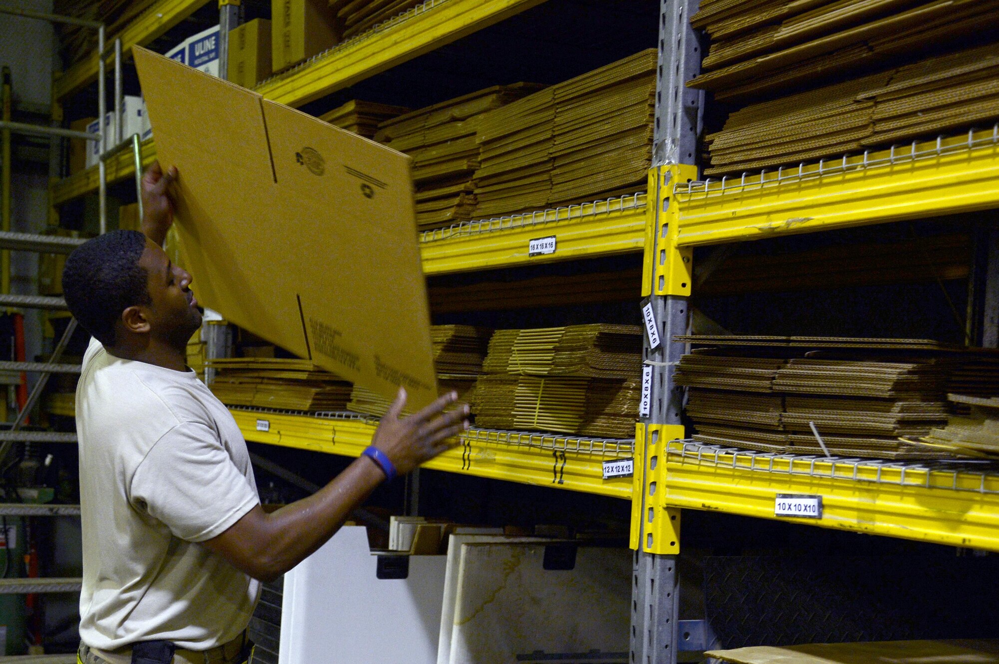 Staff Sgt. James, Traffic Management Office outbound cargo supervisor, selects a box to prepare a shipment at an undisclosed location in Southwest Asia Jan. 13, 2015. Depending on the type of asset, TMO Airmen wrap, pack, measure and label the package before sending it to the carrier. James is currently deployed from Hanscom Air Force Base, Mass., and is a native of Detroit, Mich. (U.S. Air Force photo/Tech. Sgt. Marie Brown)