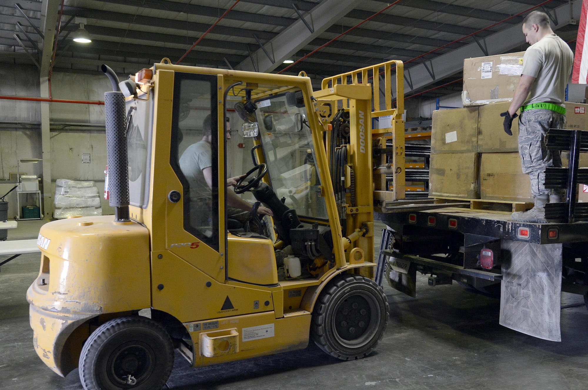 Senior Airman Raymond, inbound cargo journeyman, guides in Airman 1st Class Benjamin, inbound cargo journeyman, as they unload cargo at an undisclosed location in Southwest Asia Jan. 13, 2015. Traffic Management Airmen use equipment ranging from wood-cutting saws to 10K all-terrain forklifts to prepare cargo for storage, shipment and delivery. Raymond is currently deployed from Eielson Air Force, Alaska, and is a native of Dublin, Ga. Benjamin is currently deployed from Luke Air Force Base, Ariz., and is a native of Houston, Texas. (U.S. Air Force photo/Tech. Sgt. Marie Brown)