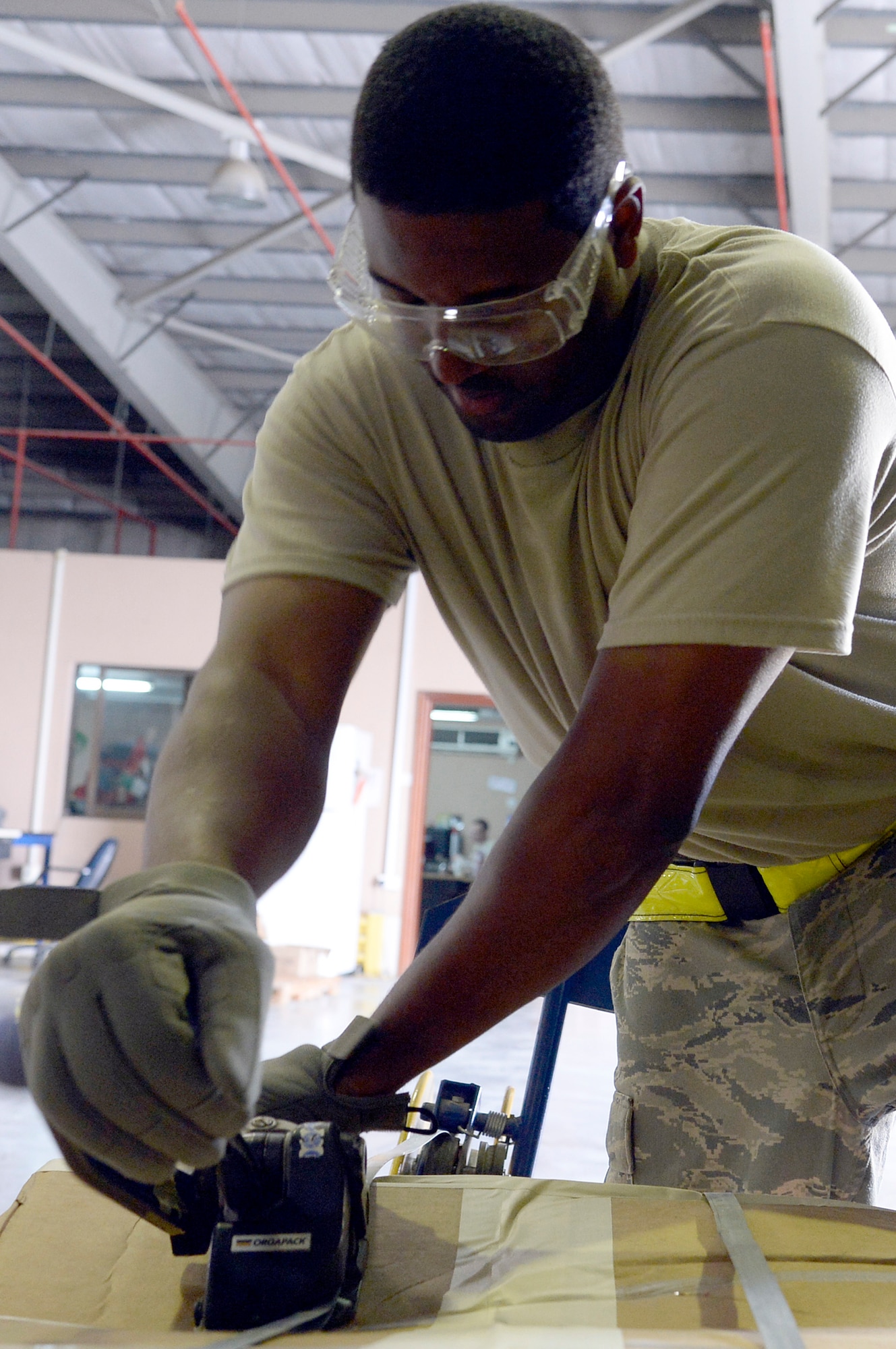 Staff Sgt. James, Traffic Management Office outbound cargo supervisor, bands a shipment to a pallet at an undisclosed location in Southwest Asia Jan. 13, 2015. Inbound and outbound cargo section assists the entire base to include all services and coalition partners. James is currently deployed from Hanscom Air Force Base, Mass., and is a native of Detroit, Mich. (U.S. Air Force photo/Tech. Sgt. Marie Brown)