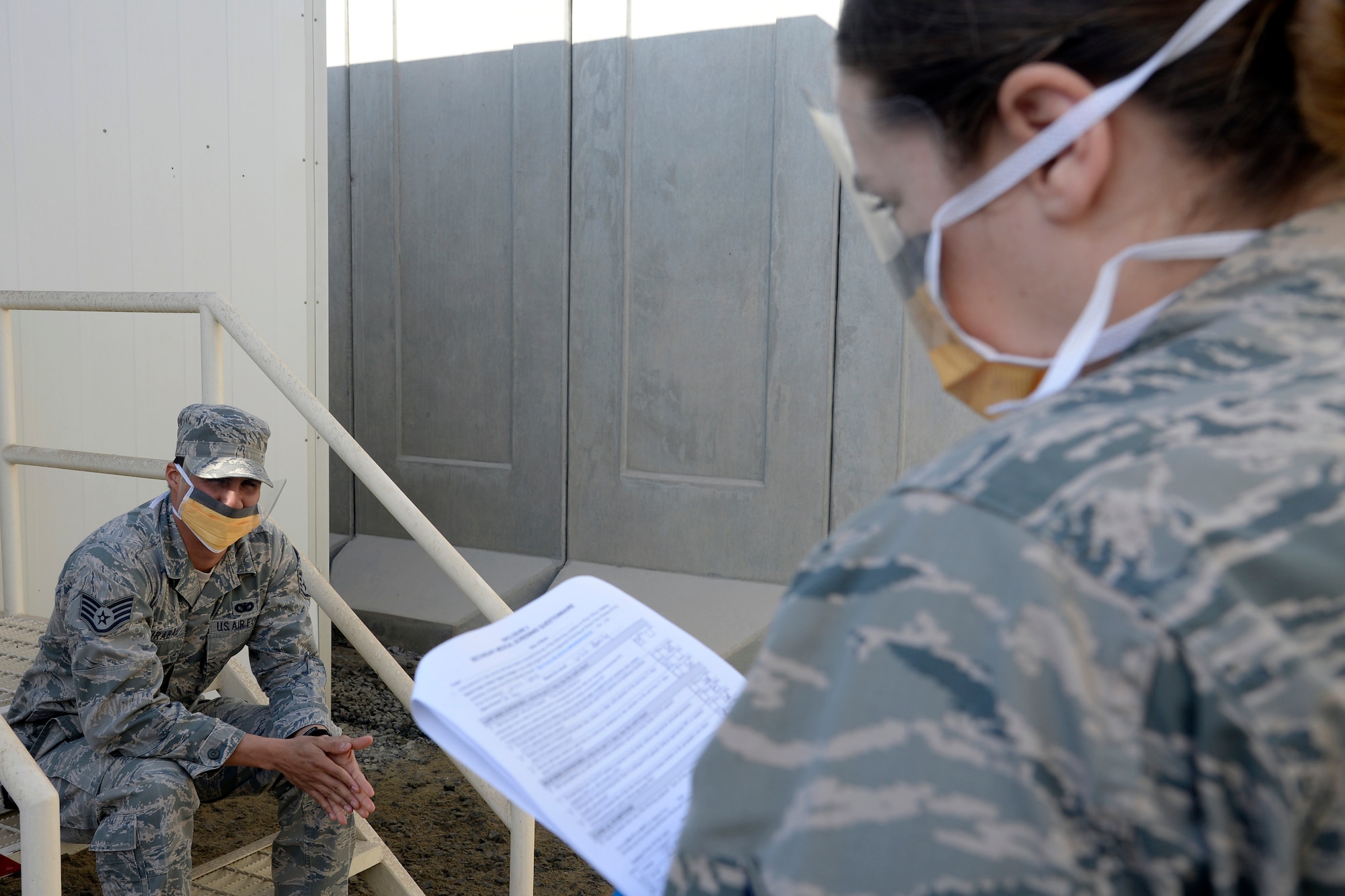 Staff Sgt. Hannah, medical technician, reviews a medical questionnaire with a possible Ebola patient during a training exercise at an undisclosed location in Southwest Asia Jan. 15, 2015. The exercise tested the Air Expeditionary Wing’s Disease Containment Plan. Hannah is currently deployed from Joint Base Langley-Eustis, Va., and is a native of Lake Forest, Calif. (U.S. Air Force photo/Tech. Sgt. Marie Brown)