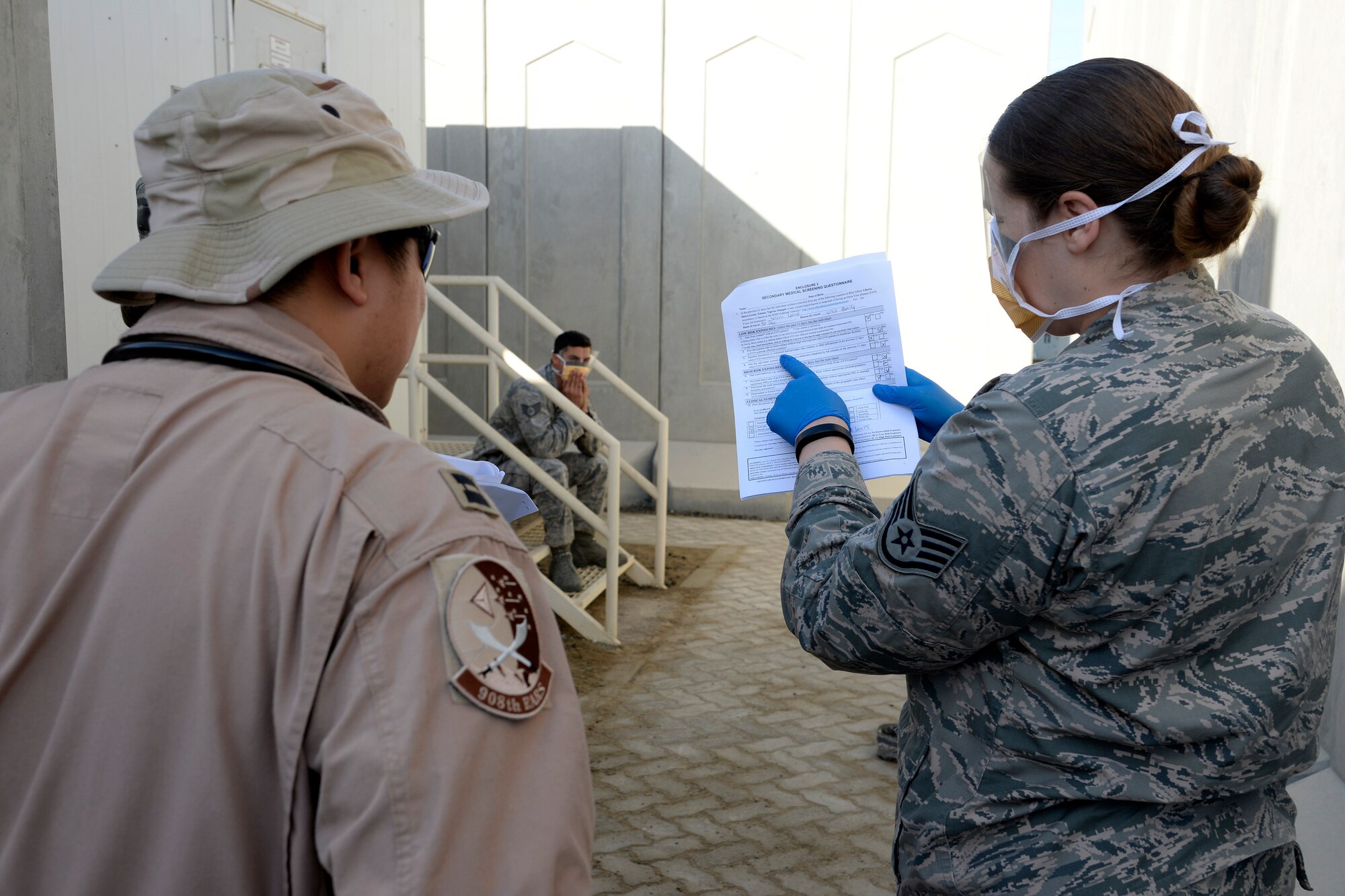 Staff Sgt. Hannah, medical technician, goes over the medical questionnaire from a simulated Ebola patient with Capt. Son Pham during a training exercise at an undisclosed location in Southwest Asia Jan. 15, 2015. Members of the Expeditionary Medical Group, Expeditionary Force Support Squadron, Expeditionary Civil Engineer Squadron and Expeditionary Security Forces Squadron took part in the exercise. Hannah is currently deployed from Joint Base Langley-Eustis, Va., and is a native of Lake Forest, Calif. (U.S. Air Force photo/Tech. Sgt. Marie Brown)
