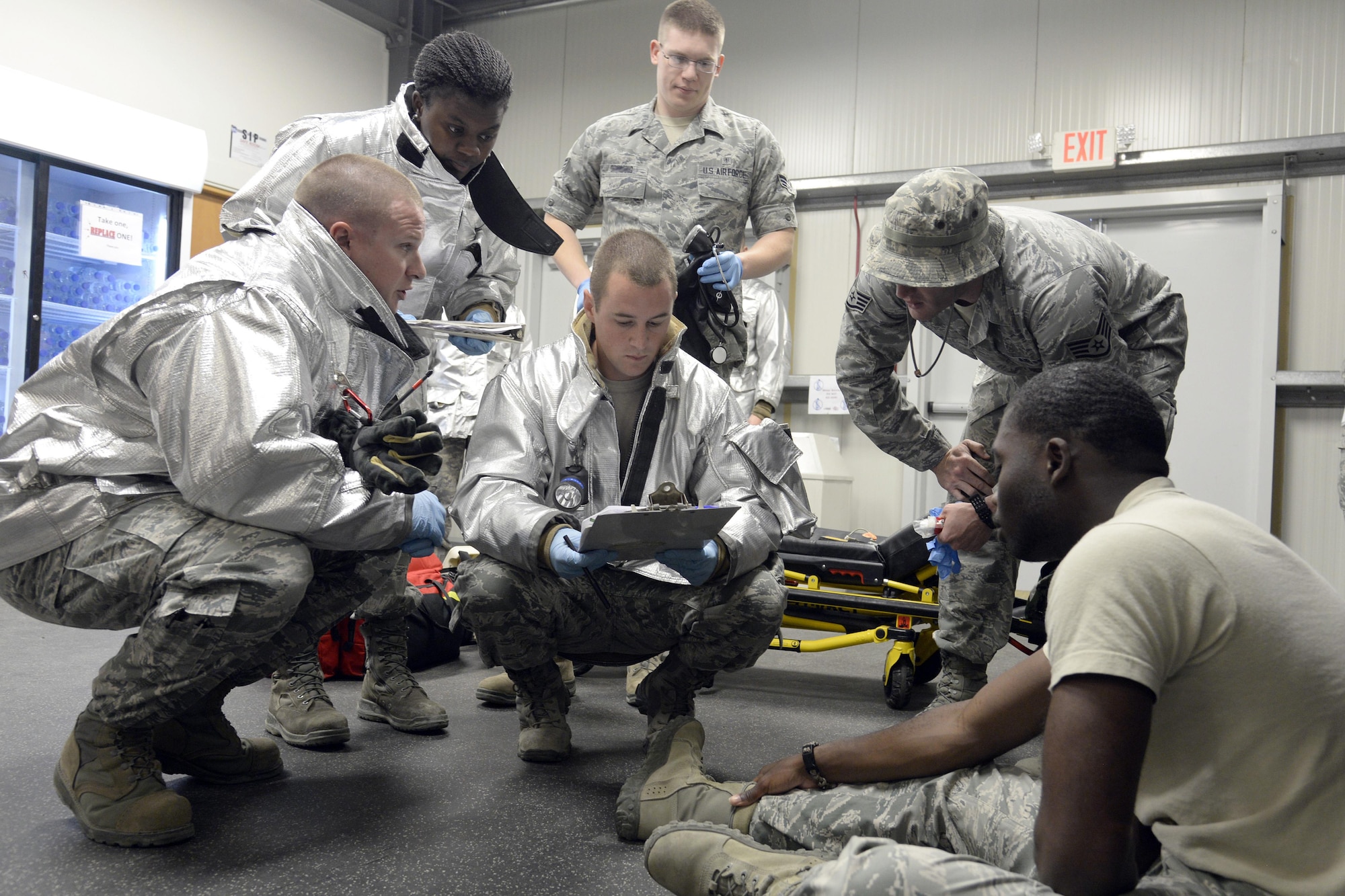 Airmen from the Expeditionary Civil Engineer Squadron and Expeditionary Medical Group evaluate a simulated patient during a training exercise at an undisclosed location in Southwest Asia Jan. 15, 2015. The Airmen were evaluated on identifying symptoms, locating a secure area for the quarantine and isolation of the patients as well as coordinating aeromedical evacuation for the patients. (U.S. Air Force photo/Tech. Sgt. Marie Brown)
