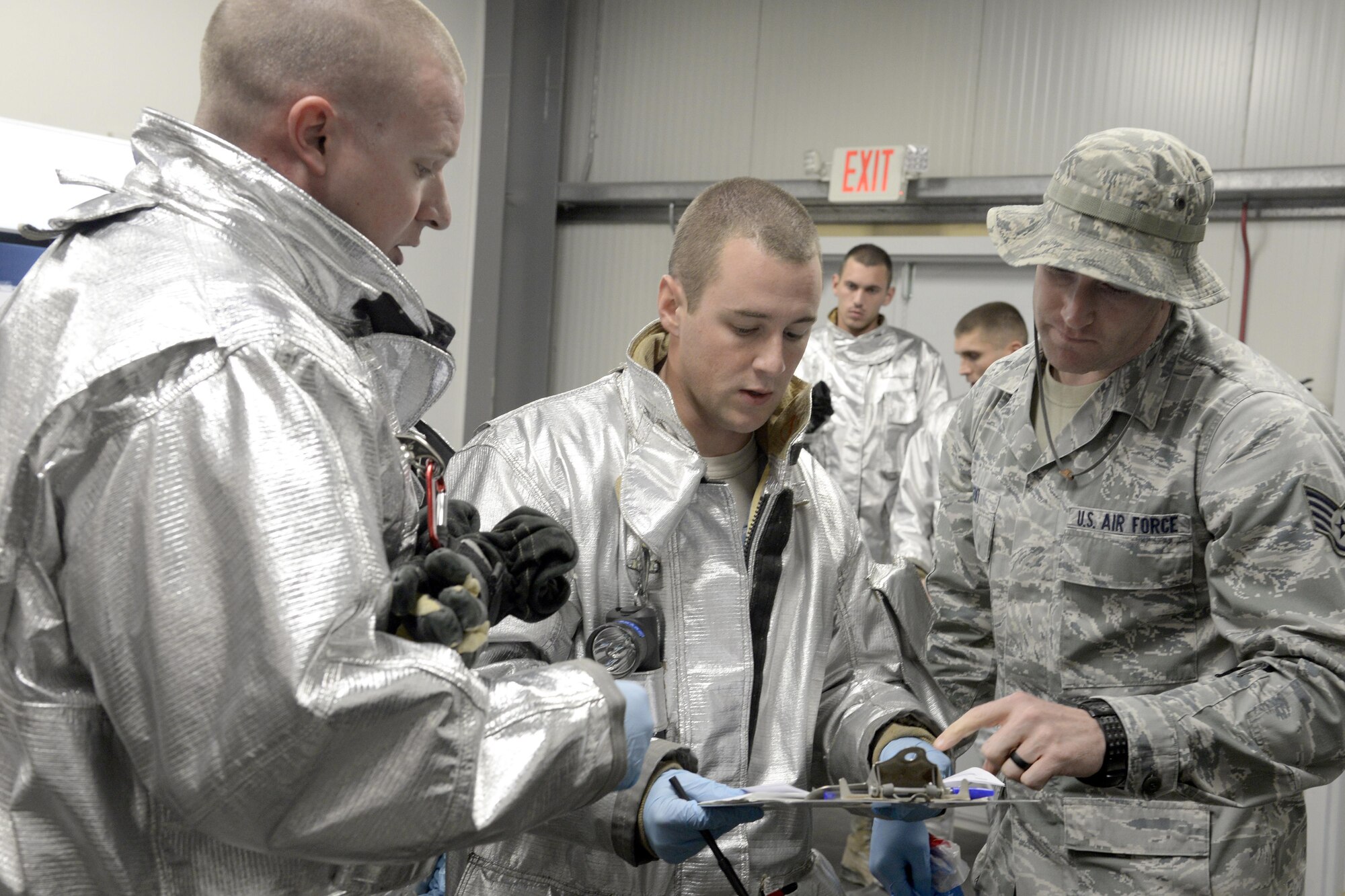 Staff Sgt. Kyle, Expeditionary Civil Engineer Squadron crew chief, and Senior Airman Austin, fire truck driver and operator, review a medical questionnaire with Staff Sgt. Joshua, medical technician, during a training exercise at an undisclosed location in Southwest Asia Jan. 15, 2015. Kyle is currently deployed from Beale Air Force Base, Calif., and is a native of Vacaville, Calif. Austin is currently deployed from Travis Air Force Base, Calif., and is a native of Twinfalls, Idaho. Joshua is currently deployed from Joint Base Langley-Eustis, Va., and is a native of Celina, Ohio. (U.S. Air Force photo/Tech. Sgt. Marie Brown)