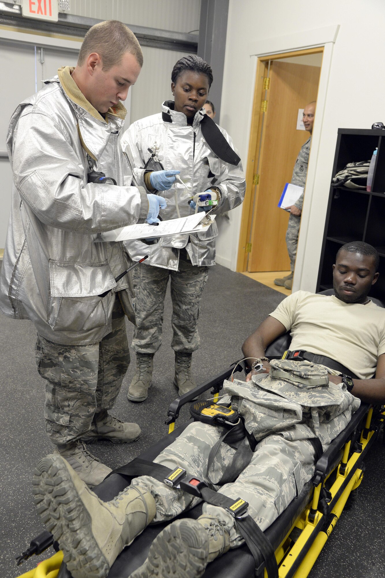 Senior Airman Austin, fire truck driver and operator, and Airman 1st Class Tianna, firefighter, record the vitals of a simulated patient during a training exercise at an undisclosed location in Southwest Asia Jan. 15, 2015. Members of the Expeditionary Medical Group, Expeditionary Force Support Squadron, Expeditionary Civil Engineer Squadron and Expeditionary Security Forces Squadron took part in the exercise. Austin is currently deployed from Travis Air Force Base, Calif., and is a native of Twinfalls, Idaho. Tianna is currently deployed from Beale Air Force Base, Calif., and is a native of Miami, Fla. (U.S. Air Force photo/Tech. Sgt. Marie Brown)