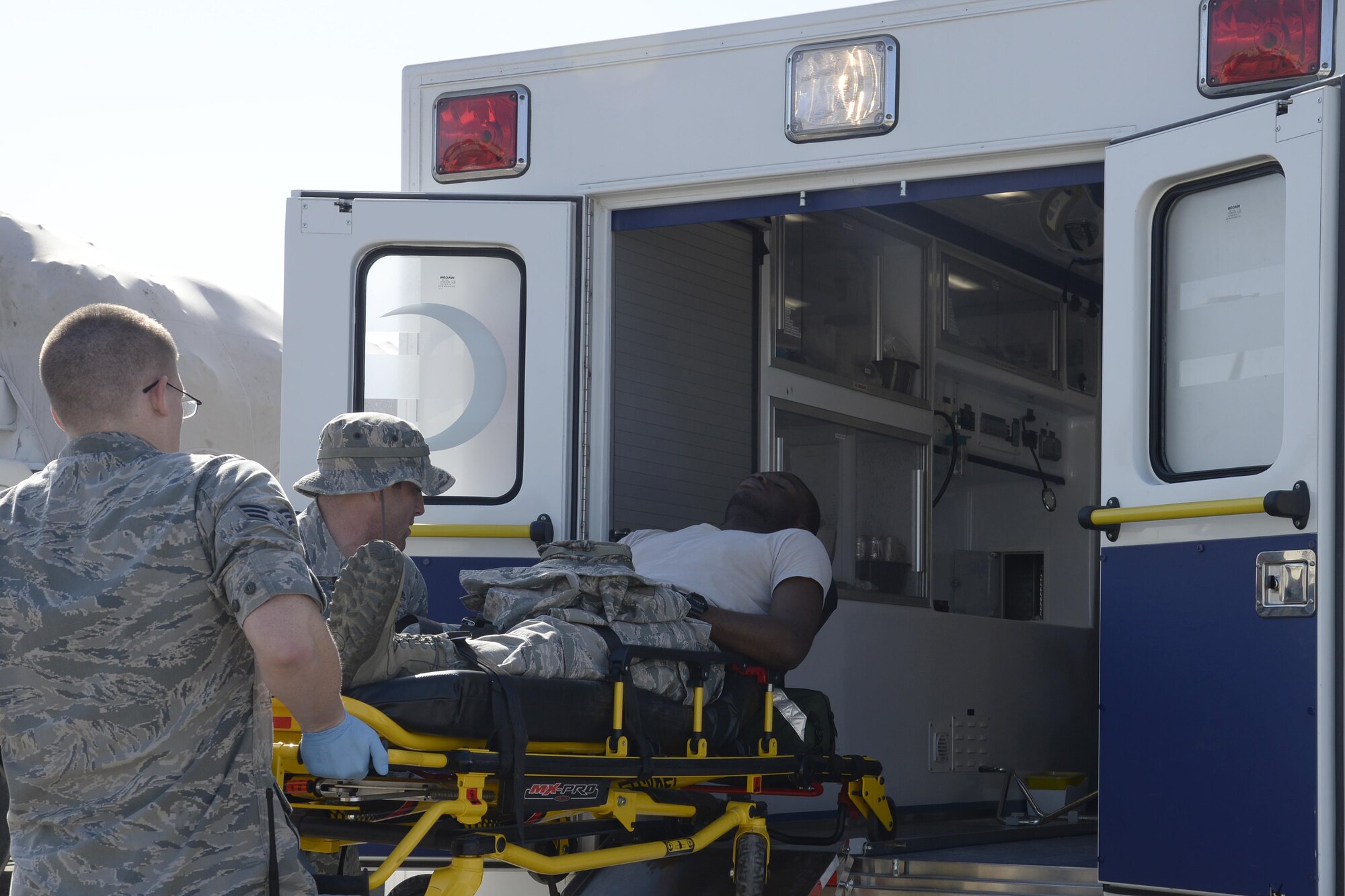 Senior Airman Garrett, left, and Staff Sgt. Joshua, medical technicians, load a simulated patient into an ambulance during a training exercise at an undisclosed location in Southwest Asia Jan. 15, 2015. Airmen participating in the exercise were given the opportunity to receive first-hand experience as well as gain learning experience on handling potential disease outbreaks. Garrett is currently deployed from Joint Base Langley-Eustis, Va., and is a native of Denver, Colo. Joshua is currently deployed from Joint Base Langley-Eustis, Va., and is a native of Celina, Ohio. (U.S. Air Force photo/Tech. Sgt. Marie Brown)