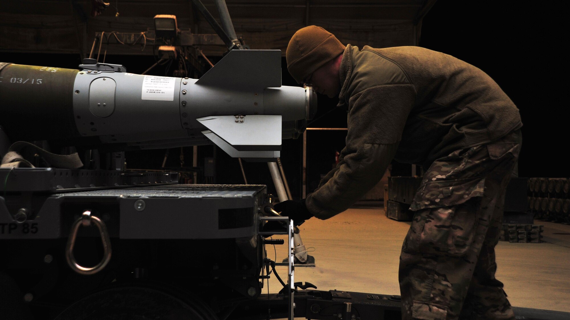 U.S. Air Force Airman 1st Class Jared Moore, 455th Expeditionary Maintenance Squadron line delivery crew member, inspects a trailer prior to transporting munitions to the flightline Jan. 14, 2015 at Bagram Airfield, Afghanistan. Line delivery Airmen have completed 741 munitions deliveries since October, ensuring the timely facilitation of airpower to the U.S. Central Command area of responsibility. (U.S. Air Force photo by Staff Sgt. Whitney Amstutz/released)