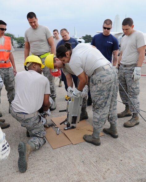 Airmen from the 15th Maintenance Squadron, Hawaii Air National Guard 154th MXS and maintenance Coastguardsman install a cable into a grip hoist during a crash, damaged, disabled aircraft recovery exercise Jan. 14 2015, at Kalaeloa Airport in Kapolei, Hawaii. The grip hoist was used to stabilize an F-4 Phantom II that was raised off the ground with airbags as a part of the annual training exercise. (U.S. Air Force photo by Tech. Sgt. Aaron Oelrich/Released)