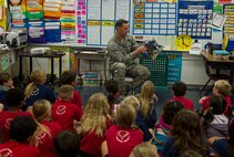 First Lt. Stephen Shaffer, 8th Intelligence Squadron section commander, reads “I Have Seen the Promised Land” to a group of students at Hickam Elementary School in honor of Dr. Martin Luther King Jr. Day Jan. 15, 2015, at Joint Base Pearl Harbor-Hickam, Hawaii. In keeping with this year’s observance theme, “Remember! Act! Celebrate! A Day on Not a Day off,” more than 30 Airmen and Sailors read books which were biographical or promoted the principals King stood by to elementary children in the local community. (U.S. Air Force photo by Tech. Sgt. Terri Paden)