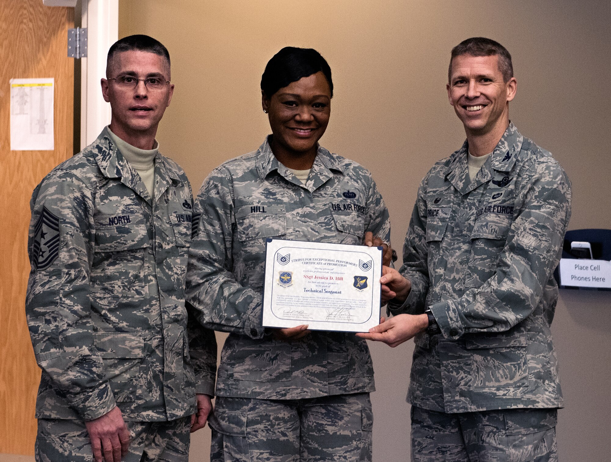 Tech. Sgt. Jessica Hill, 305th Operations Support Squadron combat crew communications section chief, stands with 305th Air Mobility Wing Command Chief Master Sgt. Daniel North and Col. John Price, 305th AMW commander, after receiving a promotion as part of the Stripes for Exceptional Performers program Jan. 6, 2015 at Joint Base McGuire-Dix-Lakehurst. STEP promotions allow commanders a limited opportunity to immediately promote enlisted members and recognize Airmen who exhibit exceptional potential. (U.S. Air Force photo by Staff Sgt. Katherine Tereyama/RELEASED)
