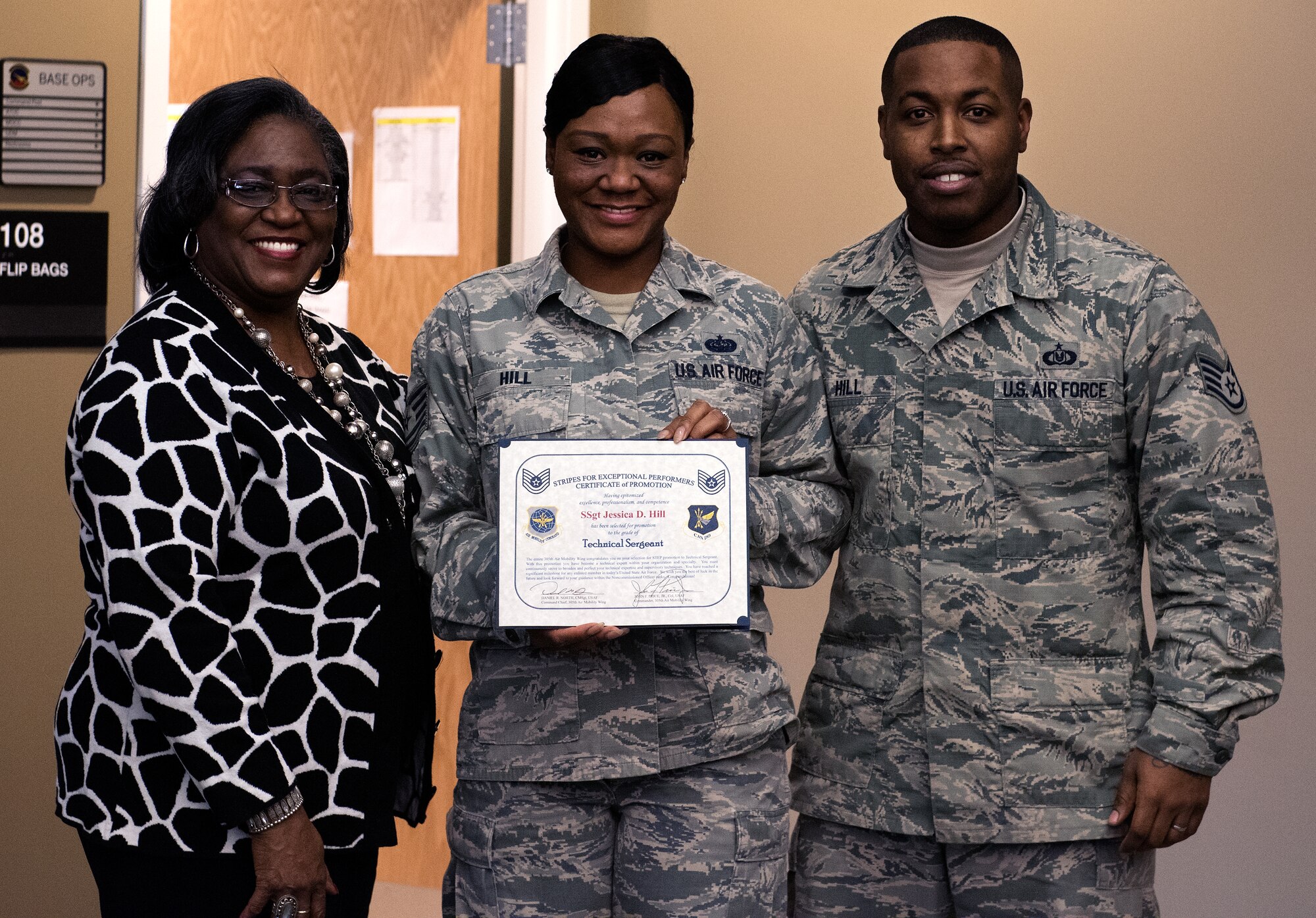 Tech. Sgt. Jessica Hill, 305th Operations Support Squadron combat crew communications section chief, stands with her mother, Jessie Stevenson and her husband, Staff Sgt. Nickolas Hill, 305th OSS aircrew flight equipment technician, after receiving a promotion as part of the Stripes for Exceptional Performers program Jan. 6, 2015 at Joint Base McGuire-Dix-Lakehurst. STEP promotions allow commanders a limited opportunity to immediately promote enlisted members and recognize Airmen who exhibit exceptional potential. (U.S. Air Force photo by Staff Sgt. Katherine Tereyama/RELEASED)
