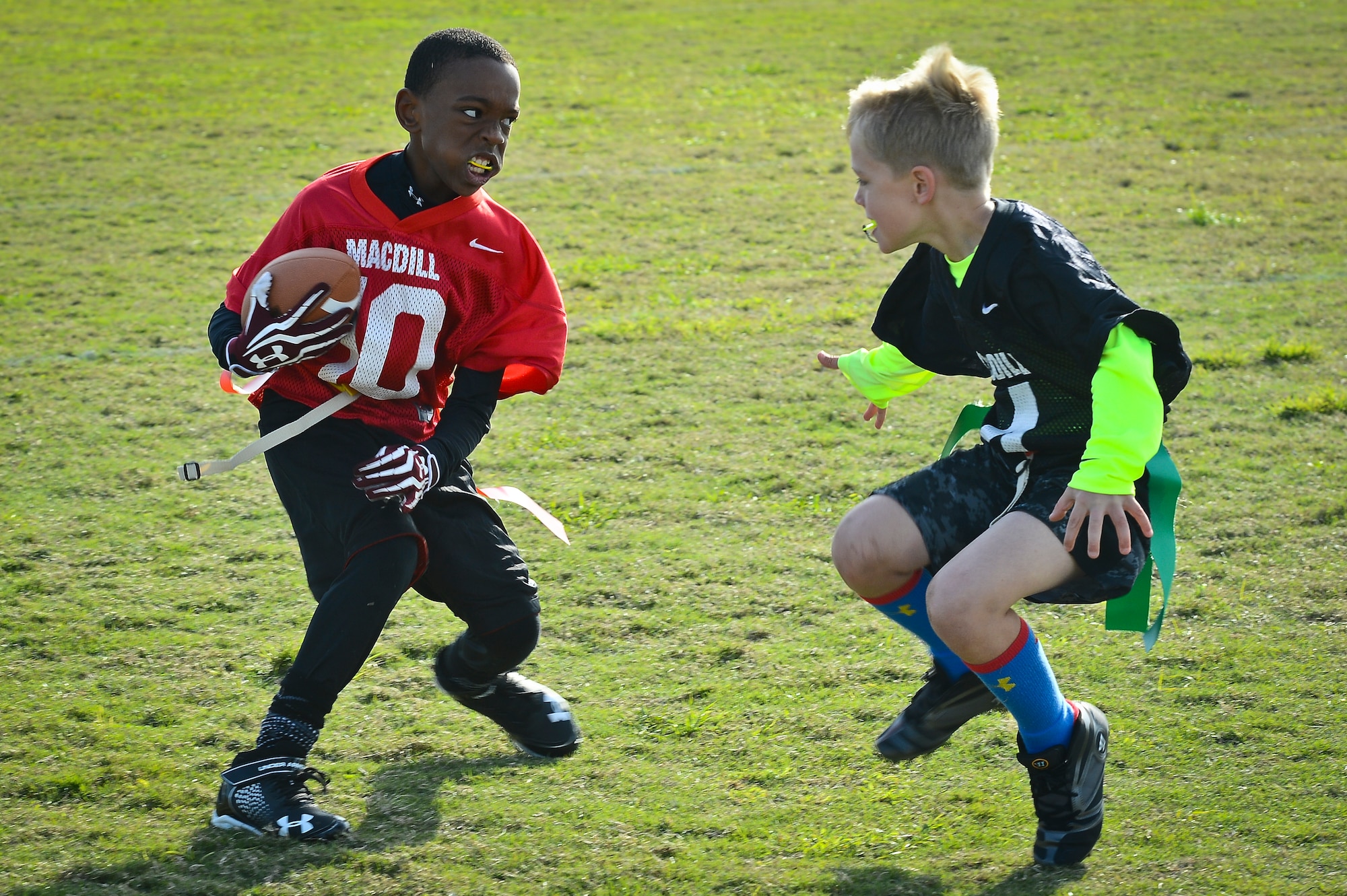 Two children play flag football as part of the youth program’s inaugural flag football season at MacDill Air Force Base, Fla., January 10, 2015. On average, the youth programs have anywhere from 80 through 200 participants and has room to grow for new kids. (U.S. Air Force photo by Senior Airman Ned T. Johnston/Released)
