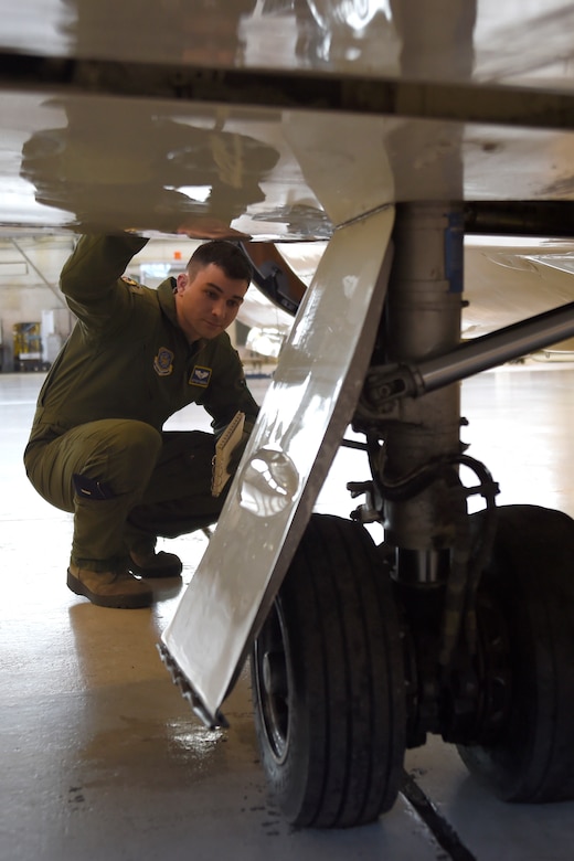 1st Lt. Jeff Morrow, 457th Airlift Squadron pilot, inspects landing gear during a pre-flight check of a C-21 on Joint Base Andrews, Md., Jan. 9, 2015. The inspector looks for: loose fittings, tires with tread separation, low inflation pressure, and other defects that could deem the aircraft unsafe. (U.S. Air Force photo/Airman 1st Class Ryan J. Sonnier)