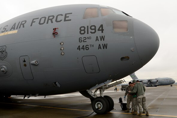Airmen from the 62nd Aircraft Maintenance Squadron perform hydraulics maintenance on a C-17 Globemaster III Jan. 12, 2015 at Joint Base Lewis-McChord, Wash. The 62nd AMXS began using cross utilization training to certify four crew chiefs in hydraulics tasks to assist with low manning numbers in the hydraulics section.  (U.S. Air Force photo/ Staff Sgt. Tim Chacon) 