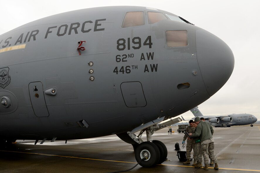 Airmen from the 62nd Aircraft Maintenance Squadron perform hydraulics maintenance on a C-17 Globemaster III Jan. 12, 2015 at Joint Base Lewis-McChord, Wash. The 62nd AMXS began using cross utilization training to certify four crew chiefs in hydraulics tasks to assist with low manning numbers in the hydraulics section.  (U.S. Air Force photo/ Staff Sgt. Tim Chacon) 