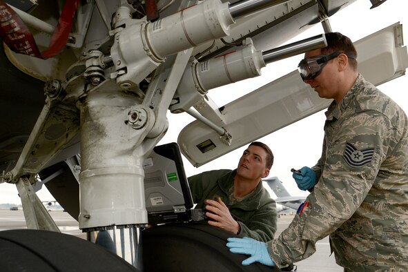 Staff Sgt. Dustin Michel, 62 Aircraft Maintenance hydraulics specialist (left) trains Tech. Sgt. Patrick Starkey, 62nd Aircraft Maintenance Squadron crew chief, on C-17 Globemaster III hydraulics maintenance, Jan. 12, 2015 at Joint Base Lewis-McChord, Wash. Starkey recently completed a four week cross utilization training course to supplement low manning numbers in the 62 AMXS hydraulics section. (U.S. Air Force photo/ Staff Sgt. Tim Chacon) 