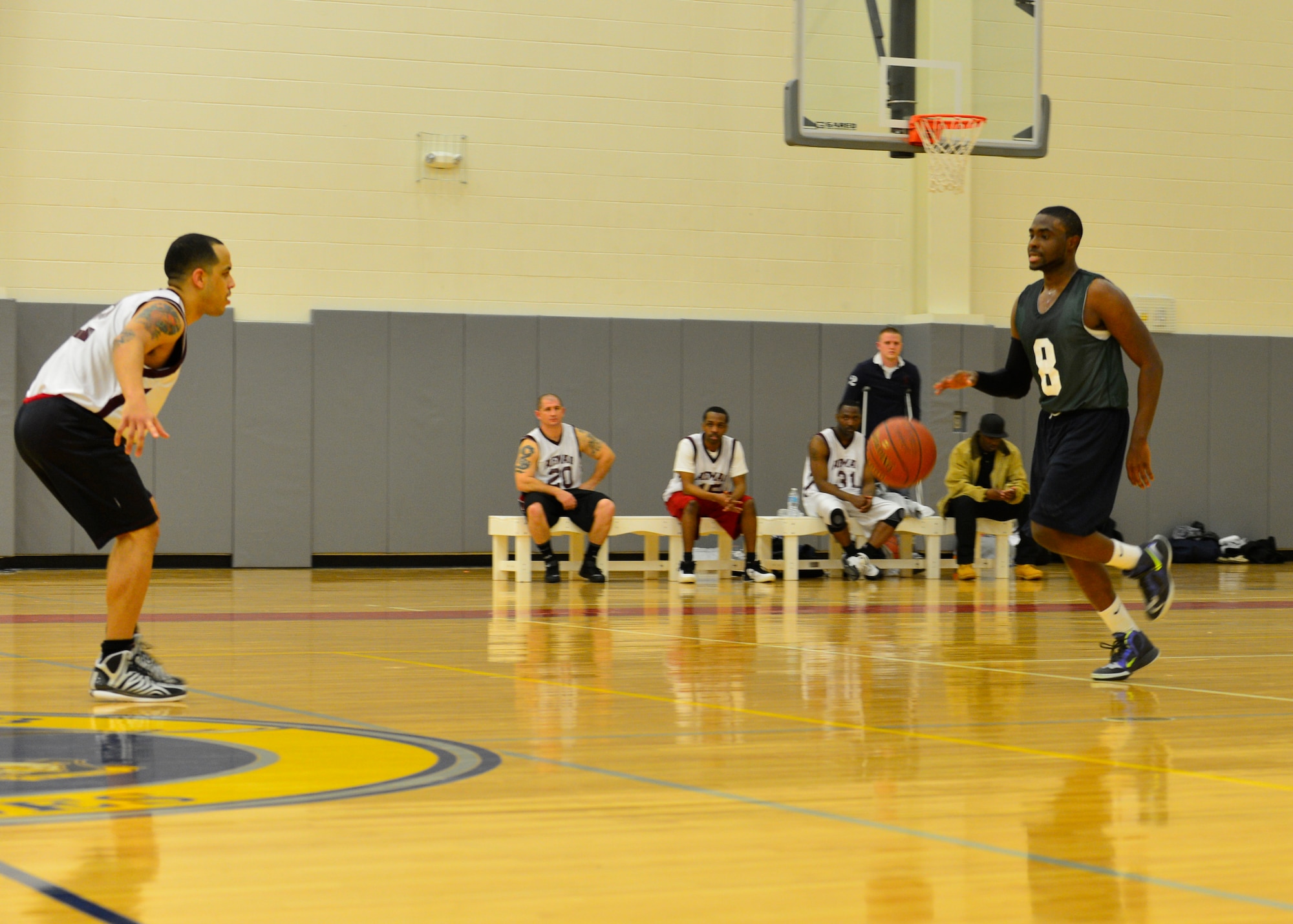 Lateef Shinaba, 512th Airlift Wing point guard moves down the court against William Molina, Air Force Mortuary Affairs Operations point guard, Jan. 15, 2015, during an intramural basketball game at the fitness center on Dover Air Force Base, Del. The 436th AW won the game by a mercy rule 57-37 with less than two minutes left to play. (U.S. Air Force photo/Airman 1st Class William Johnson)