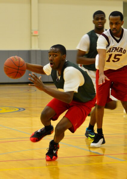 Linwood Reid, 512th Airlift Wing forward, charges in for a layup Jan. 15, 2015, in an intramural basketball game against the Air Force Mortuary Affairs Operations at the fitness center on Dover Air Force Base, Del. The 512th AW defeated AFMAO 57-37 and advanced their record to 3-1. (U.S. Air Force photo/Airman 1st Class William Johnson)