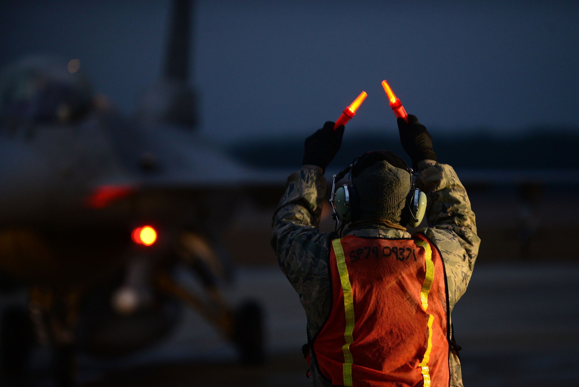 A U.S. Air Force tactical aircraft maintainer assigned to the 20th Aircraft Maintenance Squadron marshals an F-16CM Fighting Falcon during hot pit refueling at Shaw Air Force Base, S.C., Jan. 13, 2015. Tactical aircraft maintainers are responsible for the maintenance and upkeep of the jets ensuring they are ready to be flown.. (U.S. Air Force photo by Airman 1st Class Michael Cossaboom/Released)
