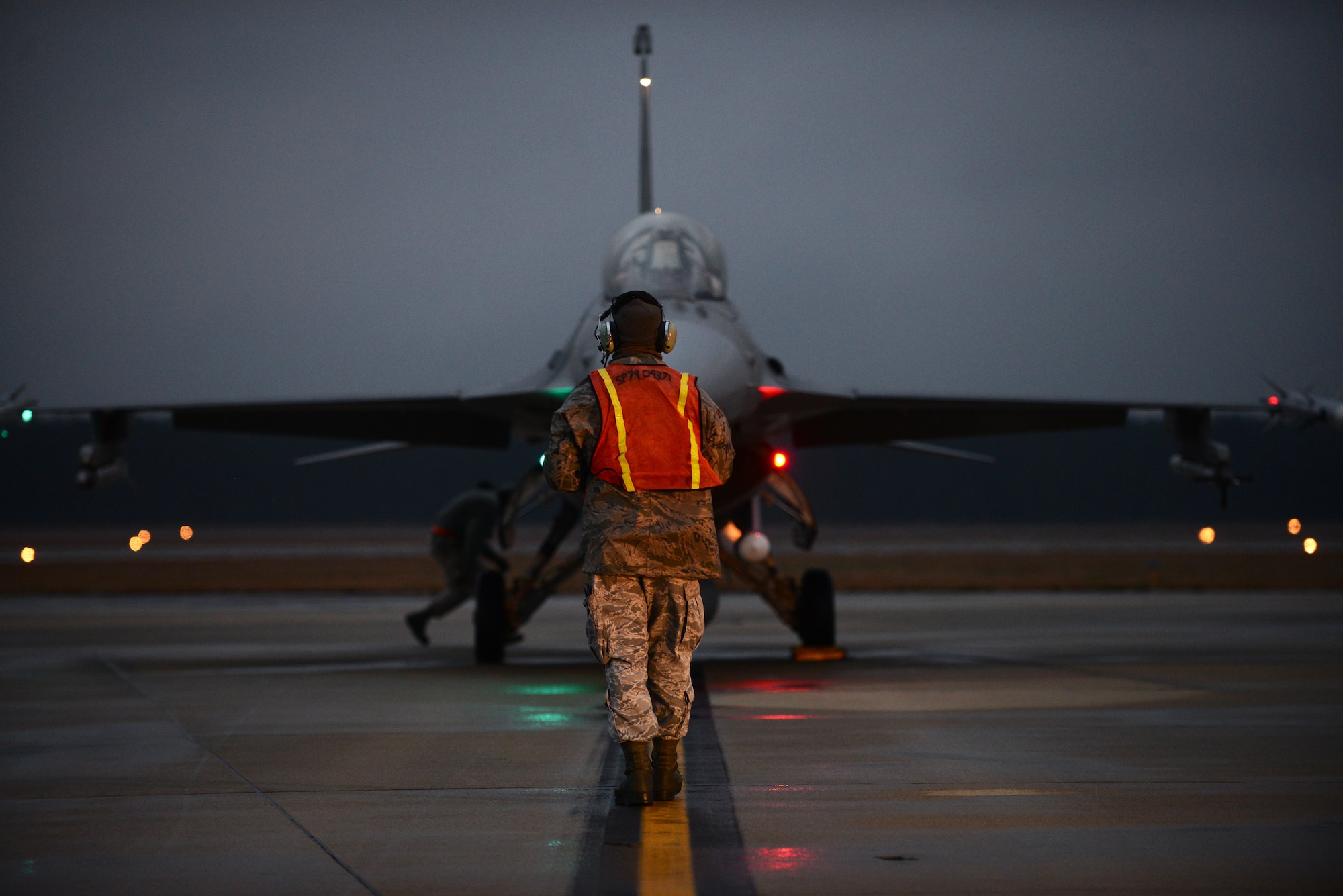 A U.S. Air Force tactical aircraft maintainer assigned to the 20th Aircraft Maintenance Squadron marshals an F-16CM Fighting Falcon during hot pit refueling at Shaw Air Force Base, S.C., Jan. 13, 2015. Hot pits are a combat refueling technique used to rapidly refuel aircraft and is typically used in combat situations. (U.S. Air Force photo by Airman 1st Class Michael Cossaboom/Released)