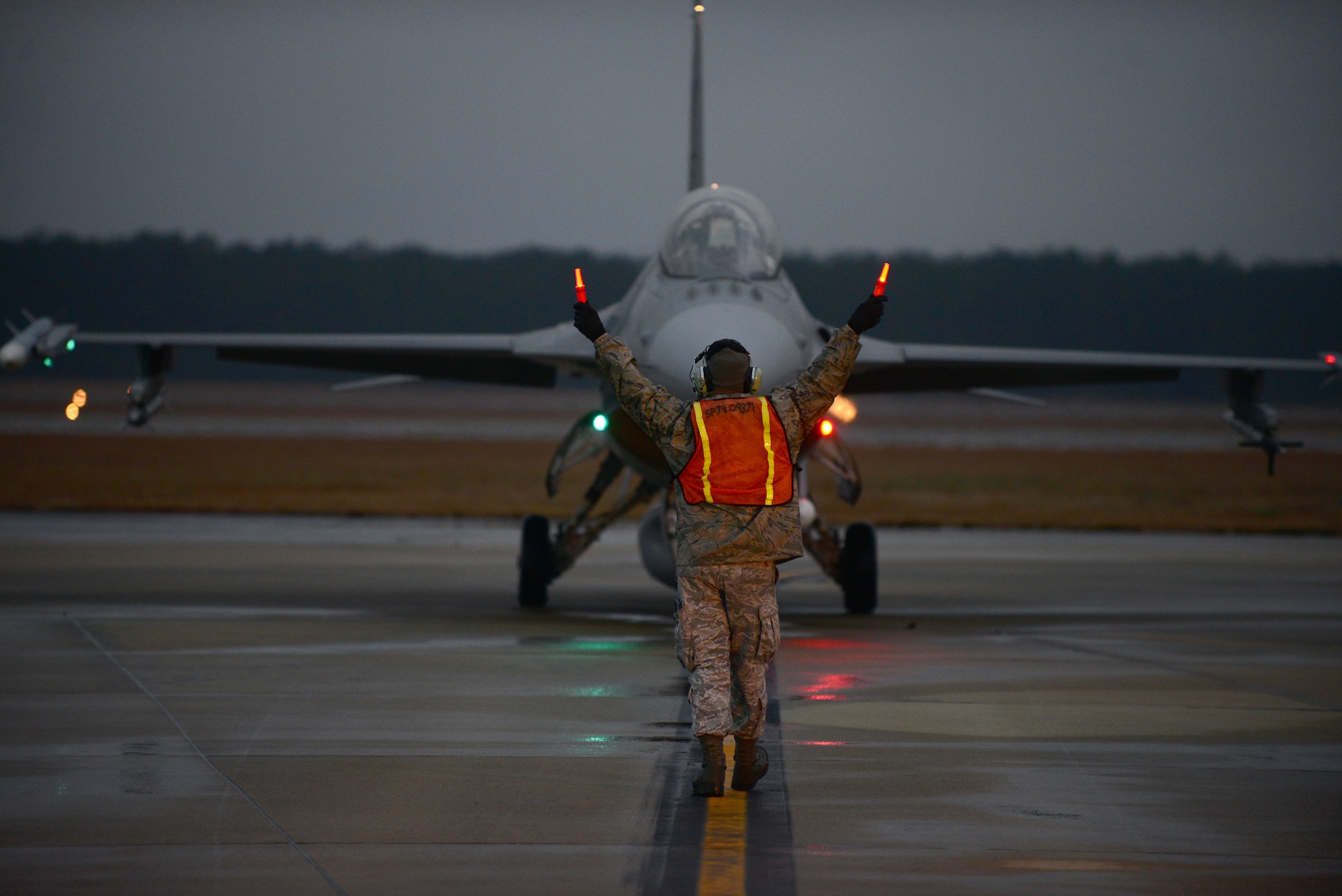 A U.S. Air Force tactical aircraft maintainer assigned to the 20th Aircraft Maintenance Squadron marshals in F-16CM Fighting Falcon during hot pit refueling at Shaw Air Force Base, S.C., Jan. 13, 2015. Hot pits are usually performed in a combat situation to rapidly refuel an aircraft and send them back into the fight. (U.S. Air Force photo by Airman 1st Class Michael Cossaboom/Released)