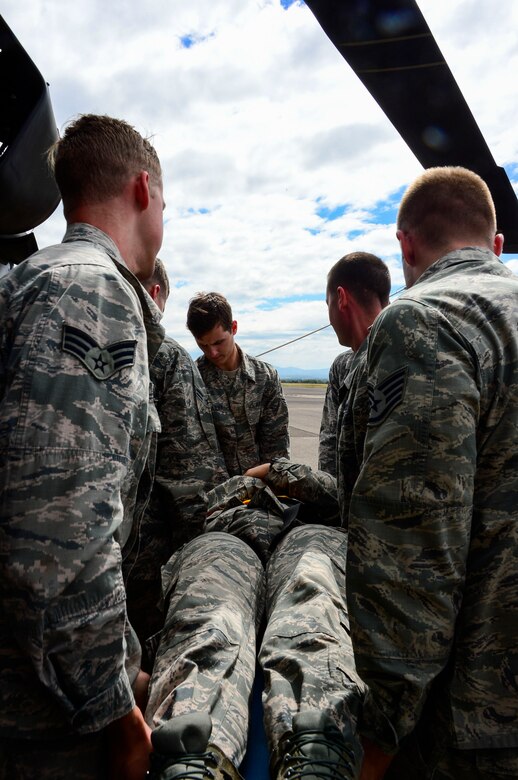 Members from the 612th Air Base Squadron Fire Department work together to carry U.S. Air Force Staff Sgt. Daniel Easterlund, 612th Air Base Squadron firefighter, on a litter from a UH-60 Blackhawk during aircraft crash rescue training at Soto Cano Air Base, Honduras, Jan. 15, 2015.  At least once a quarter, the 612th ABS teams up with the 1-228thAviation Regiment to review aircraft crash rescue training and emergency procedures for the UH-60 Blackhawk helicopter. (U.S. Air Force photo/Tech. Sgt. Heather Redman)