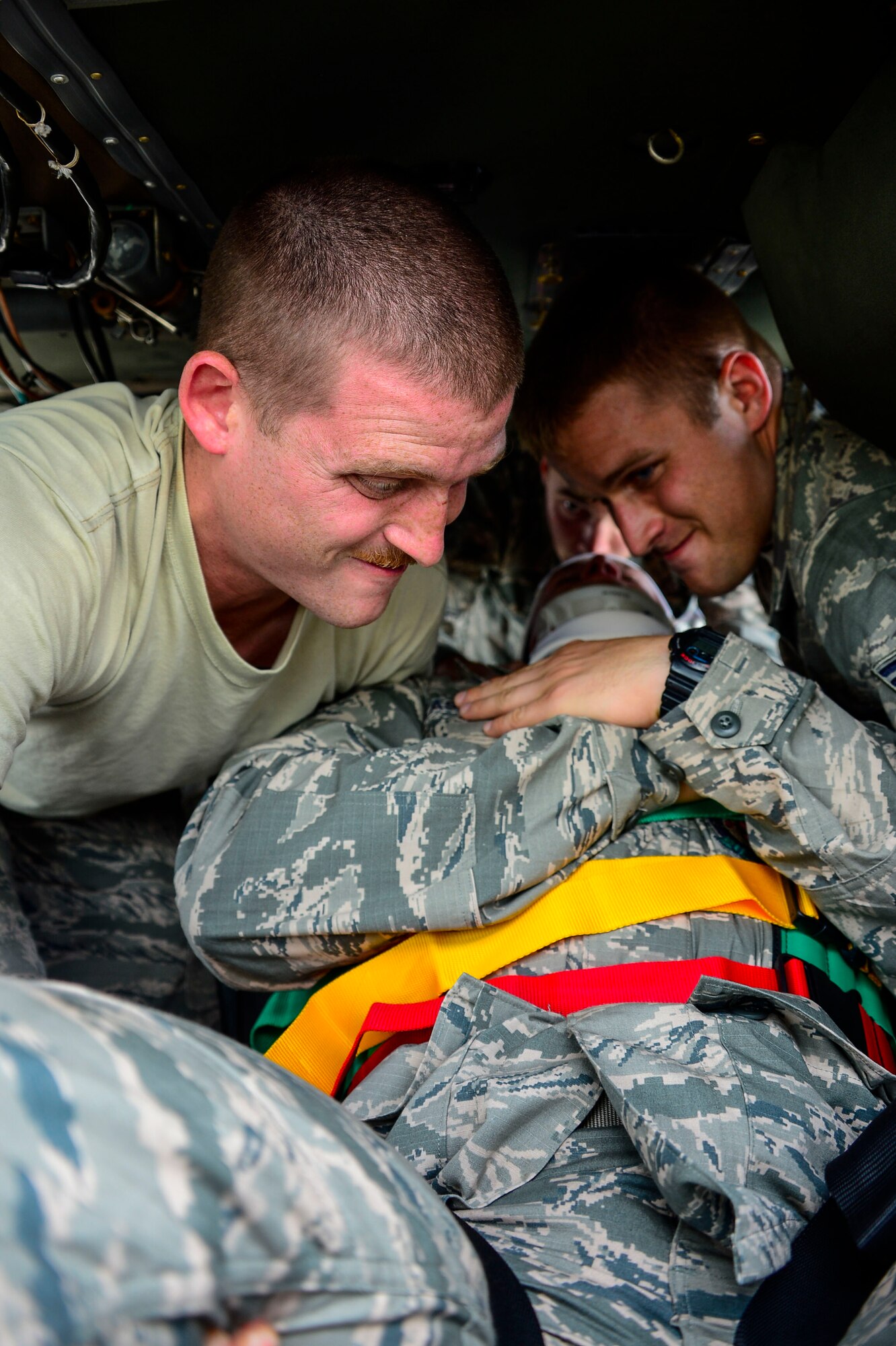 U.S. Air Force Staff Sgts. Steven White and Samuel Taylor, 612th Air Base Squadron firefighters, work together to lift U.S. Air Force Staff Sgt. Daniel Easterlund’s, 612th Air Base Squadron firefighter, on a litter during aircraft crash rescue training at Soto Cano Air Base, Honduras, Jan. 15, 2015.  At least once a quarter, the 612th ABS teams up with the 1-228th Aviation Regiment to review aircraft crash rescue training and emergency procedures for the UH-60 Blackhawk helicopter. (U.S. Air Force photo/Tech. Sgt. Heather Redman)