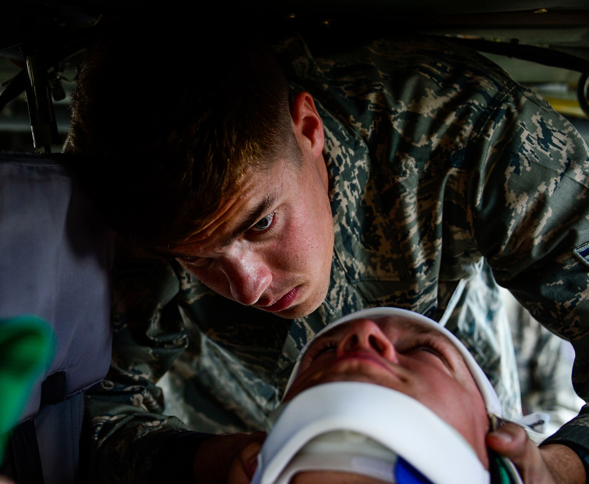 U.S. Air Force Airman 1st Class Gregory Pease, 612th Air Base Squadron firefighter, braces U.S. Air Force Staff Sgt. Daniel Easterlund’s neck during aircraft crash rescue training at Soto Cano Air Base, Honduras, Jan. 15, 2015.  At least once a quarter, the 612th ABS teams up with the 1-228th Aviation Regiment to review aircraft crash rescue training and emergency procedures for the UH-60 Blackhawk helicopter. (U.S. Air Force photo/Tech. Sgt. Heather Redman)