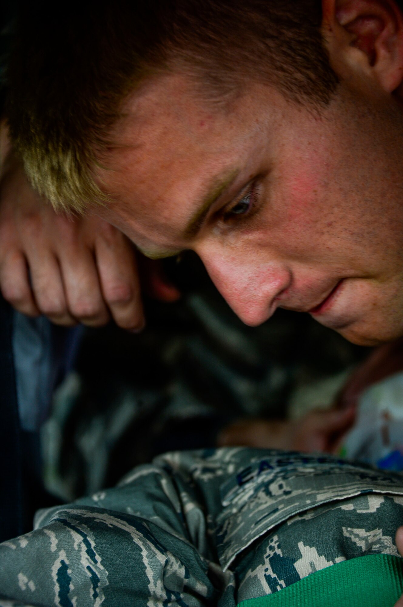 U.S. Air Force Staff Sgt. Samuel Taylor, 612th Air Base Squadron firefighter, secures the straps of a backboard to U.S. Air Force Staff Sgt. Daniel Easterlund, 612th Air Base Squadron firefighter, during aircraft crash rescue training at Soto Cano Air Base, Honduras, Jan. 15, 2015.  At least once a quarter, the 612th ABS teams up with the Aviation Regiment to review aircraft crash rescue training and emergency procedures for the UH-60 Blackhawk helicopter. (U.S. Air Force photo/Tech. Sgt. Heather Redman)